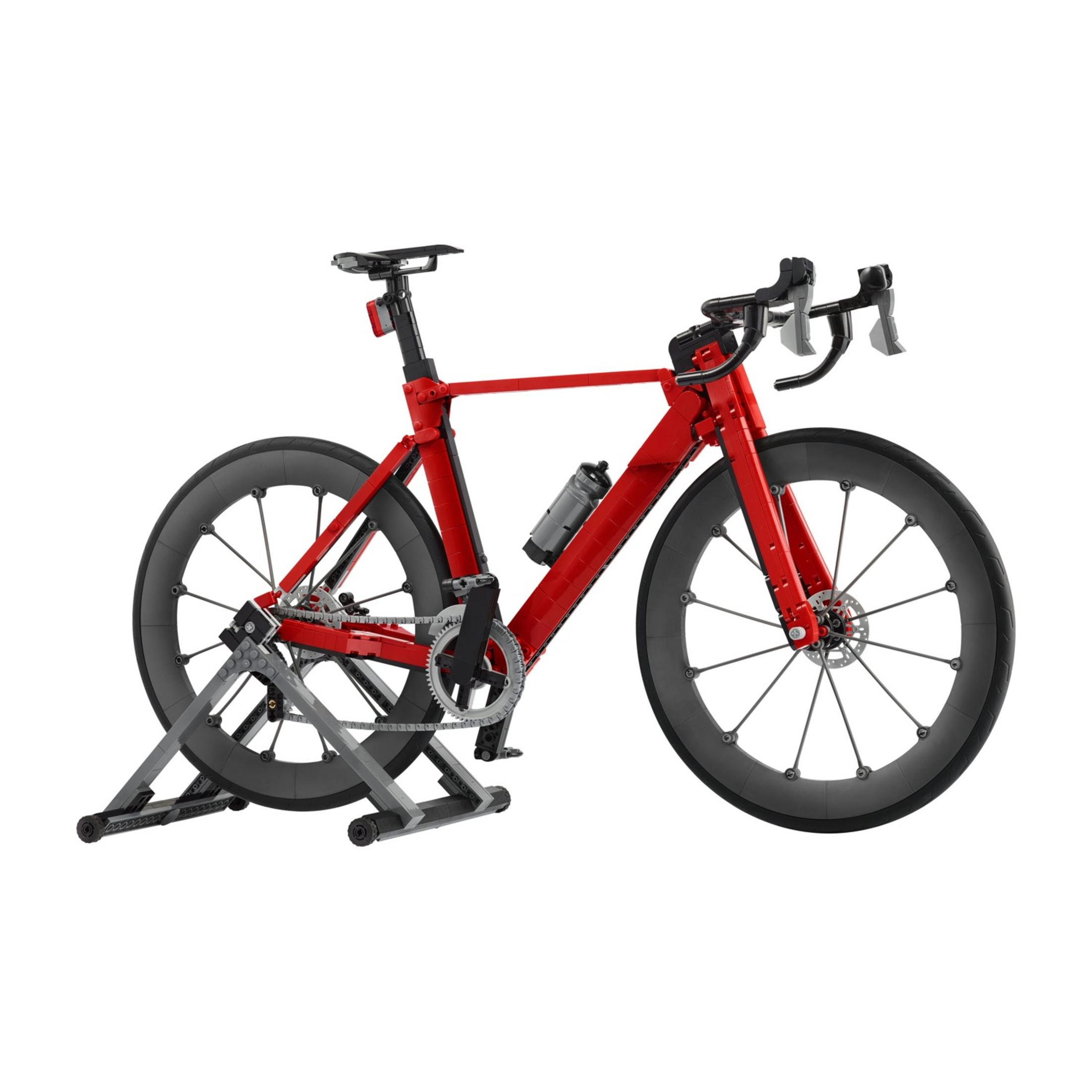 Una bicicleta de carretera roja sobre un soporte plateado con ruedas negras.