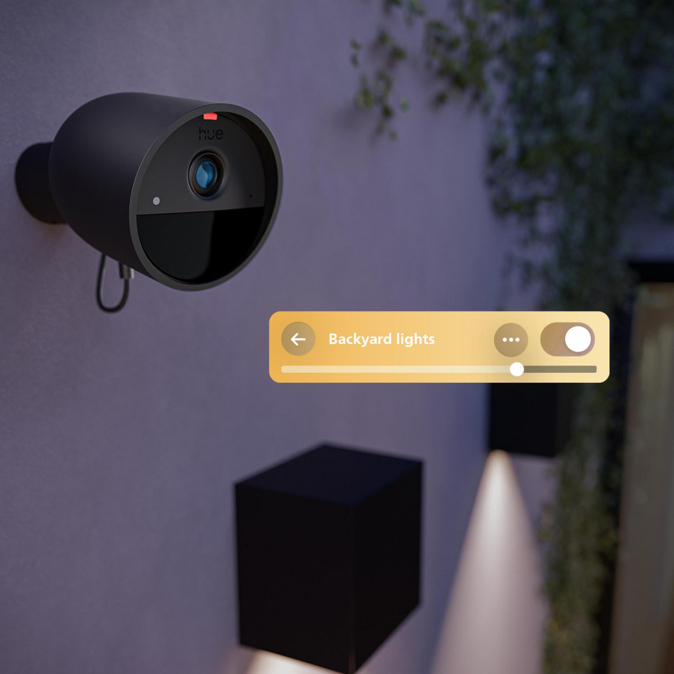 Una cámara de seguridad Hue negra en una pared con un panel de control que muestra 'Luces del patio'.