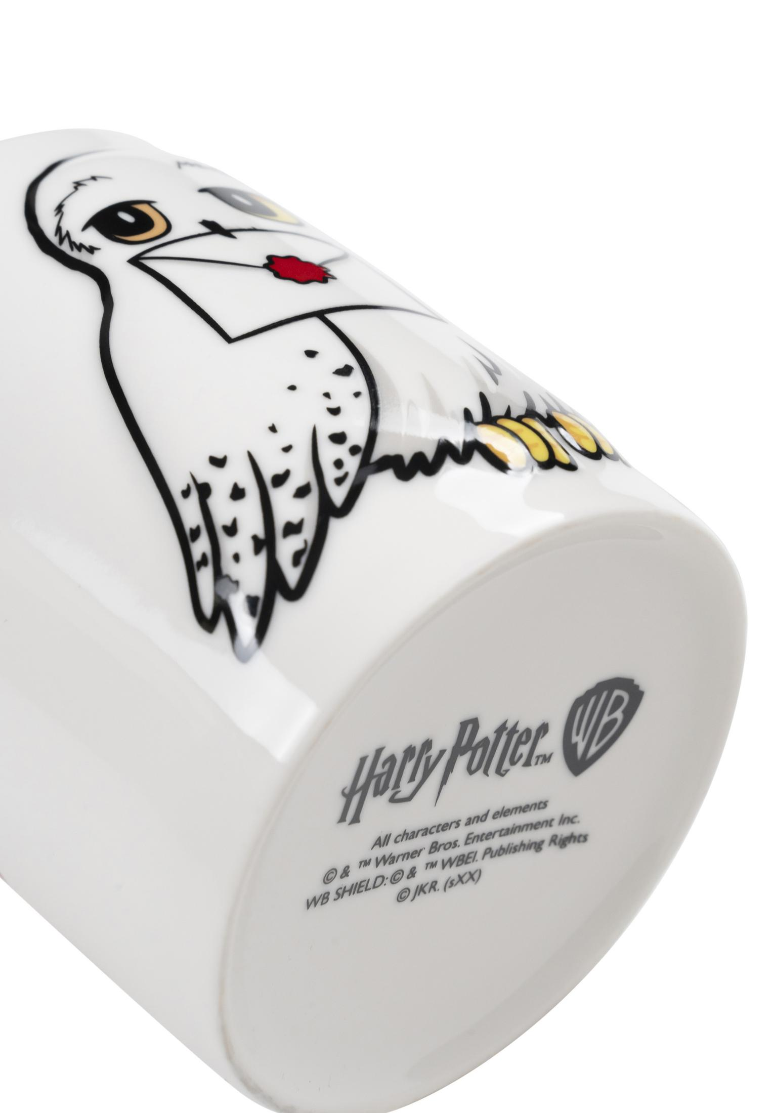 Ein weißer Becher mit einem Harry-Potter-Logo und einer Eule mit Brief.