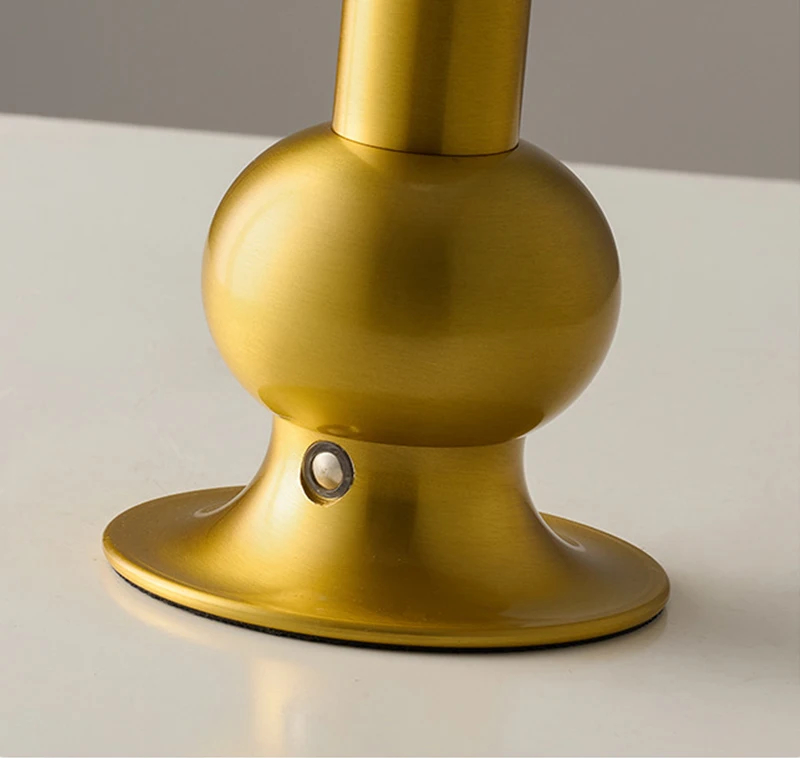 Ein goldener Sockel mit einer Kugel und einem kleinen Knopf.