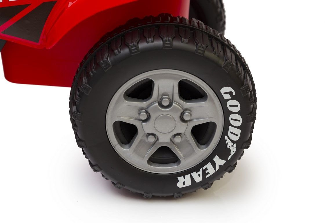 Zbliżenie czerwonego samochodu-zabawki z oponą Goodyear i srebrną felgą.