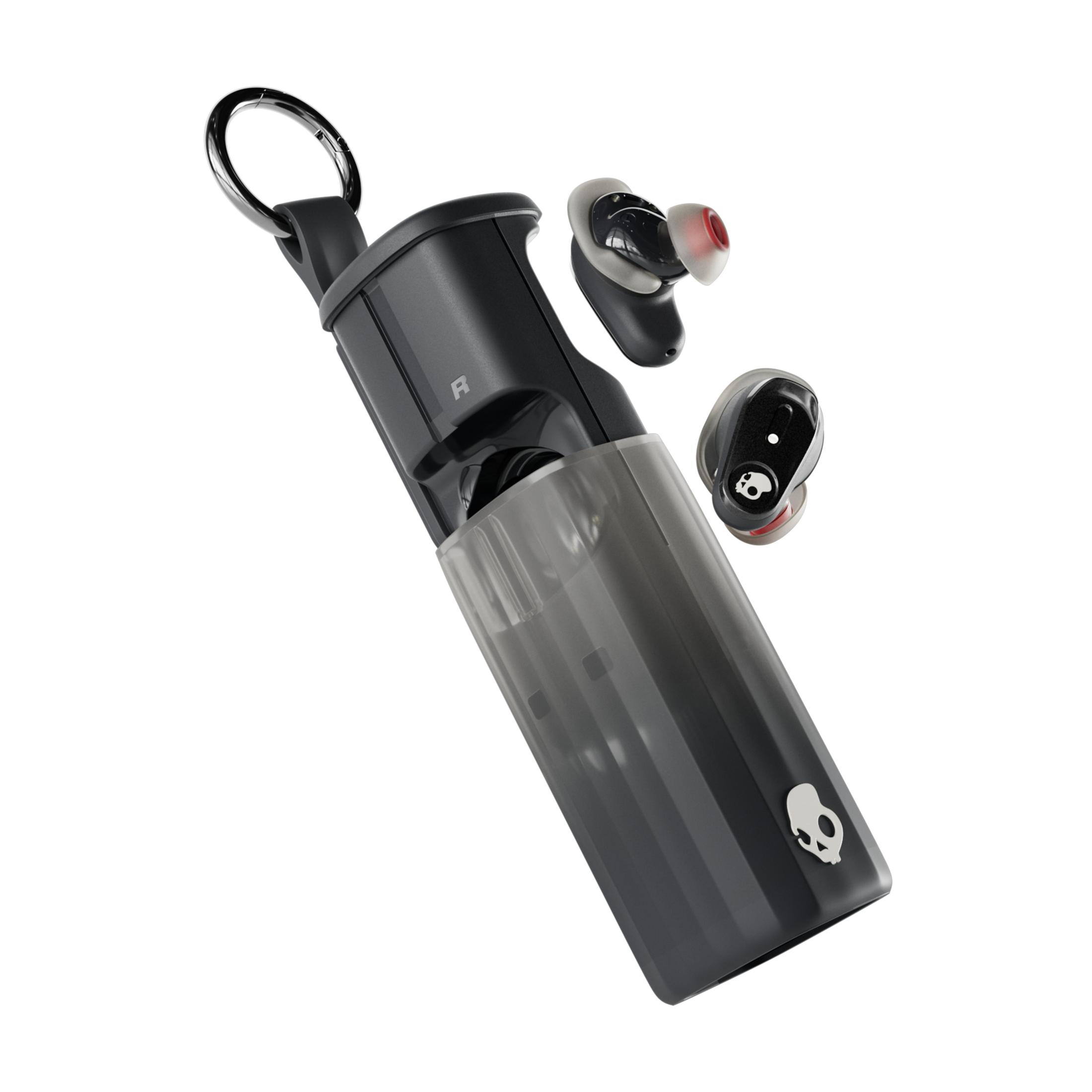 Estuche negro con auriculares, un anillo arriba, un logo de calavera abajo.