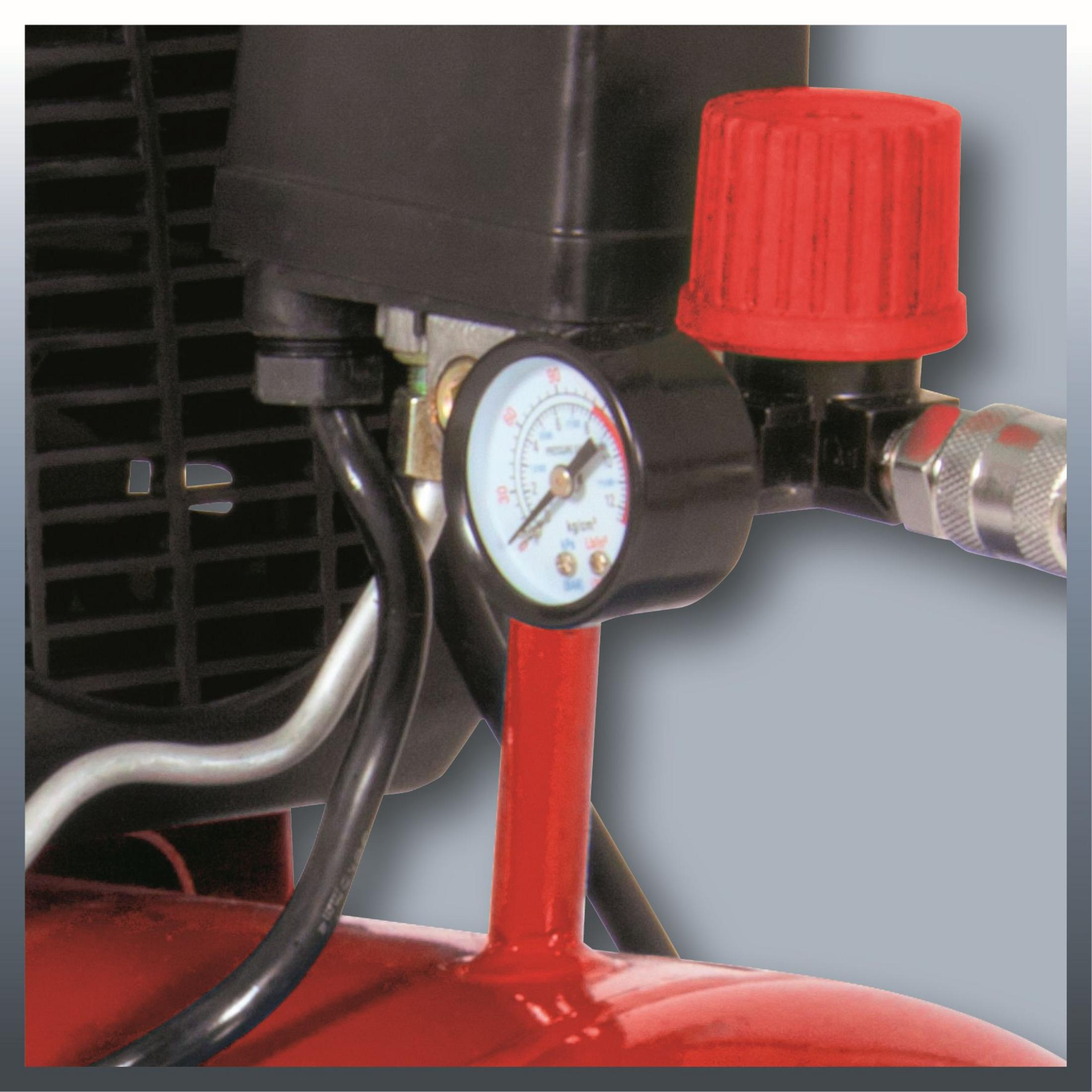 Un manometro con tappo rosso su un compressore rosso.