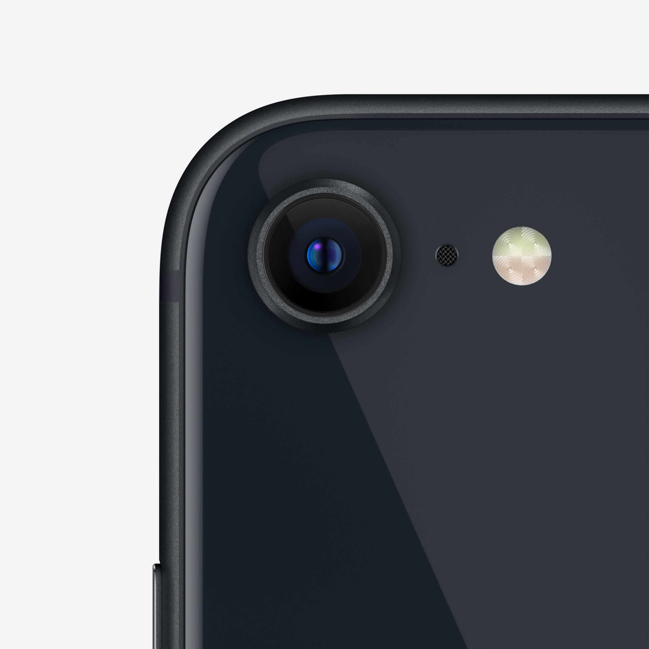 Zbliżenie tylnej części czarnego iPhone'a z aparatem i lampą błyskową.