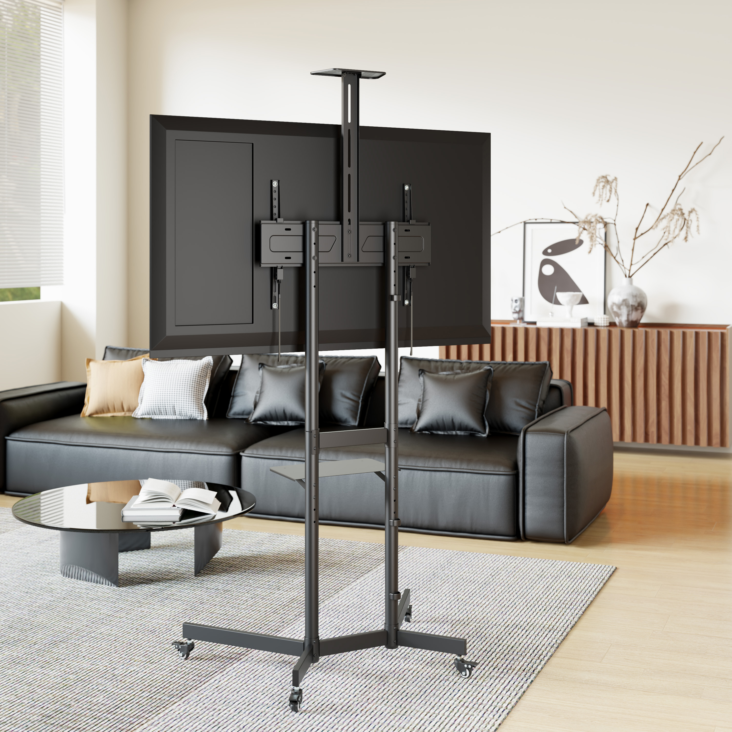 Ein freistehender TV-Ständer mit Rädern vor einem Sofa und Couchtisch.