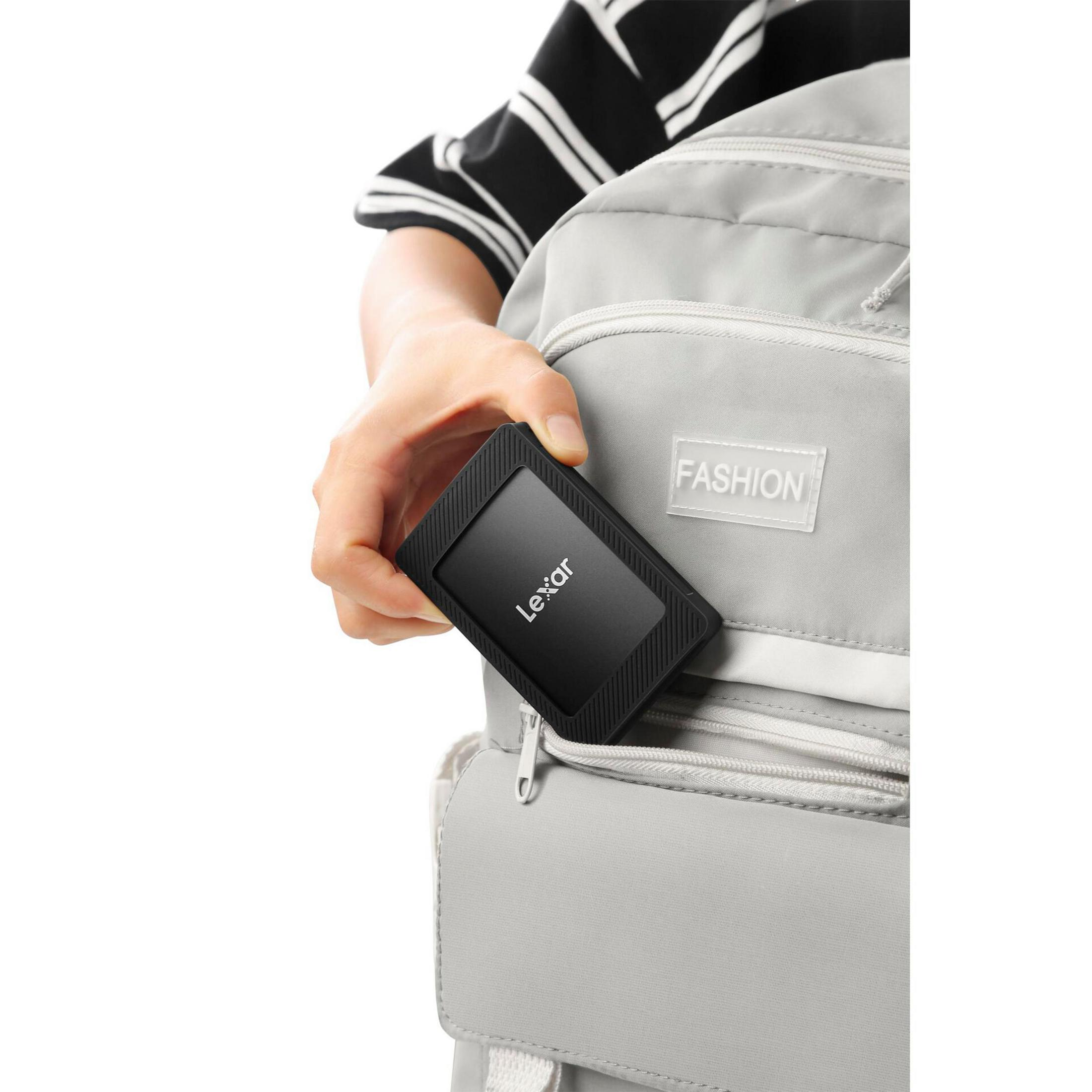 Una mano inserisce un hard disk Lexar nero in uno zaino grigio.