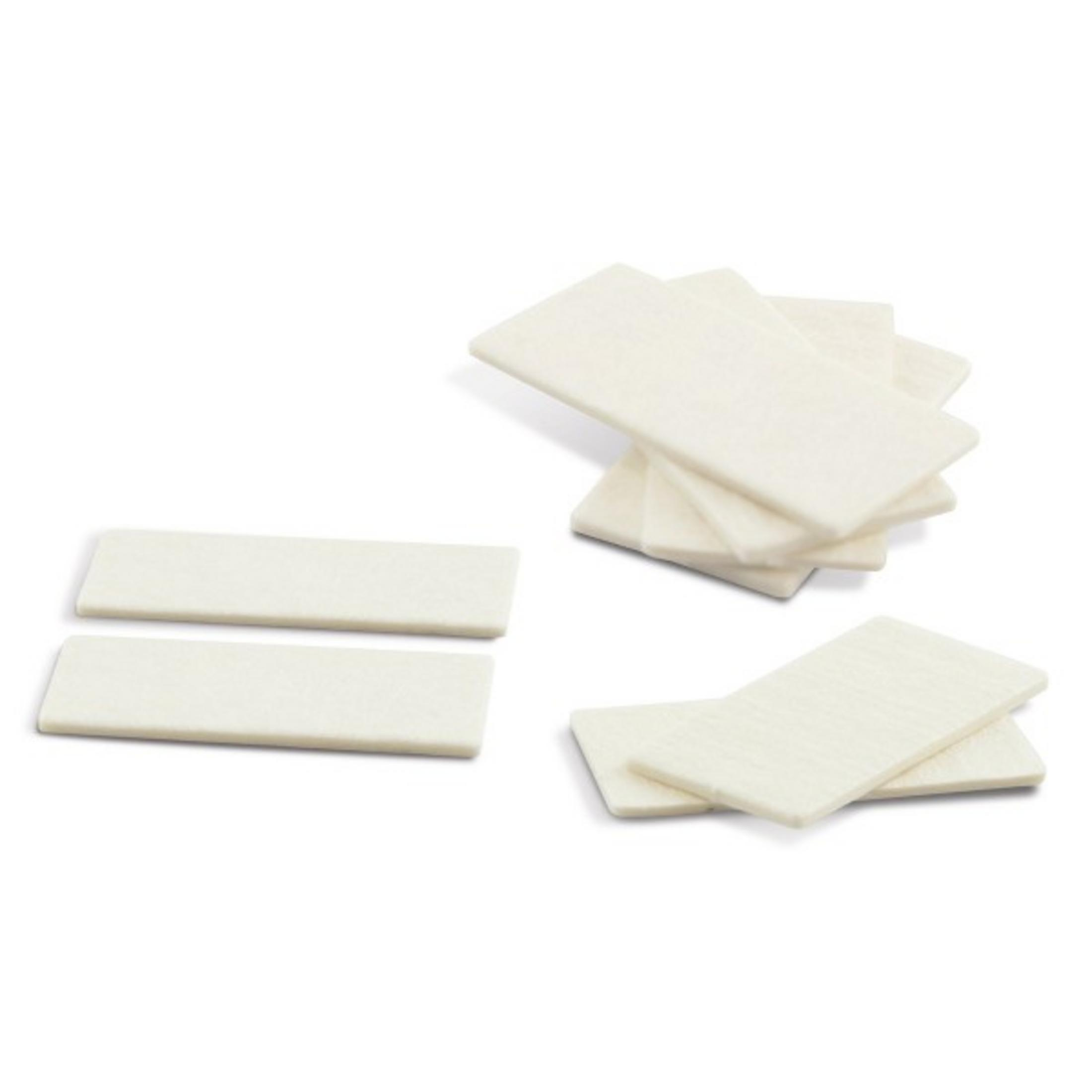 Varios objetos rectangulares blancos con textura ligera apilados sobre fondo blanco.