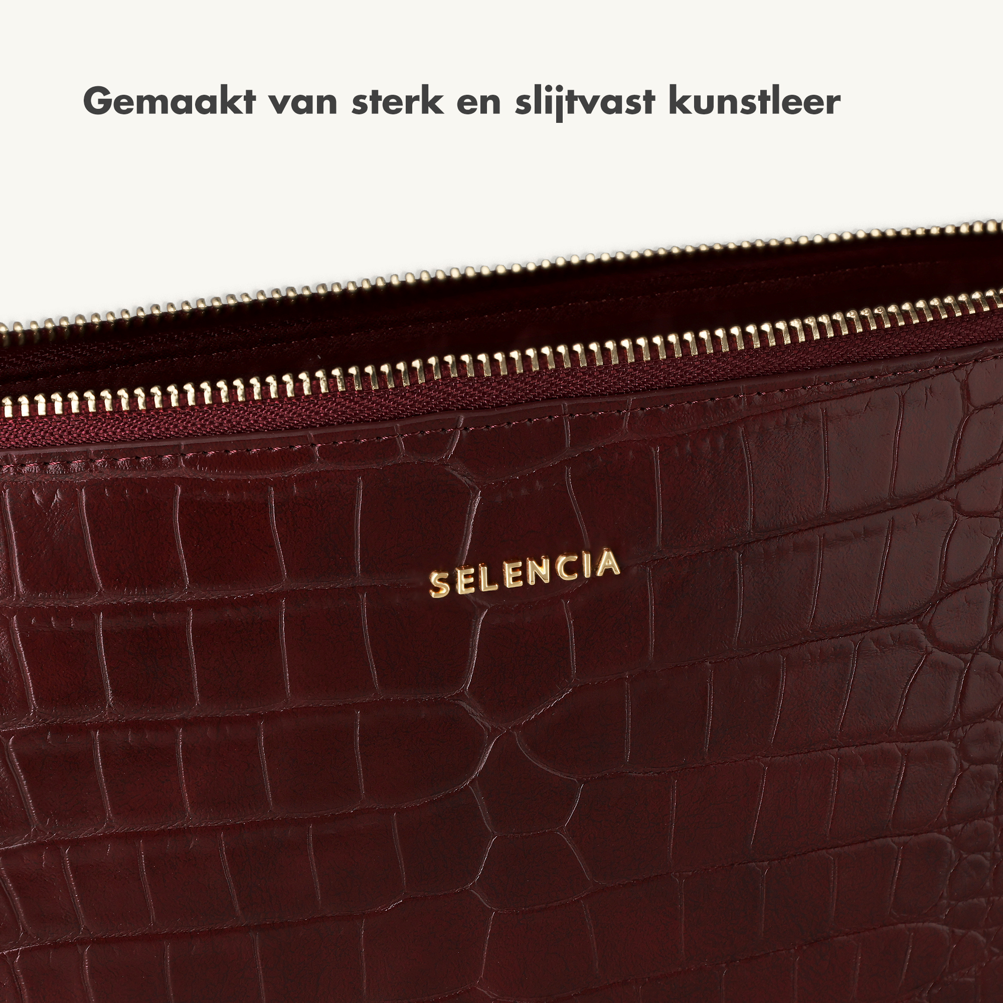 Nahaufnahme einer dunkelroten Kroko-Prägung mit goldener Schrift.
