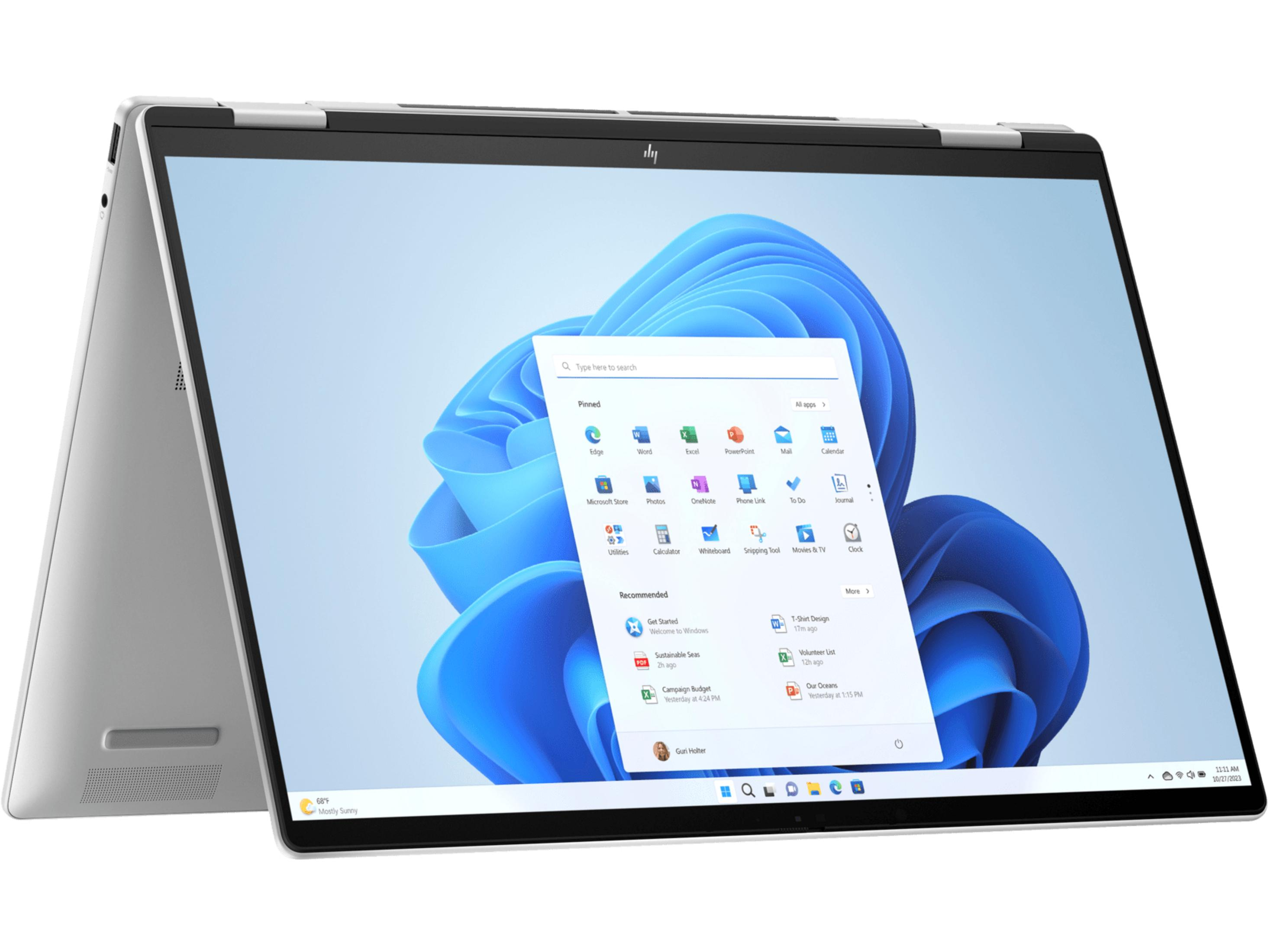 Un portátil plateado con la pantalla abierta, mostrando el menú de inicio de Windows 11.