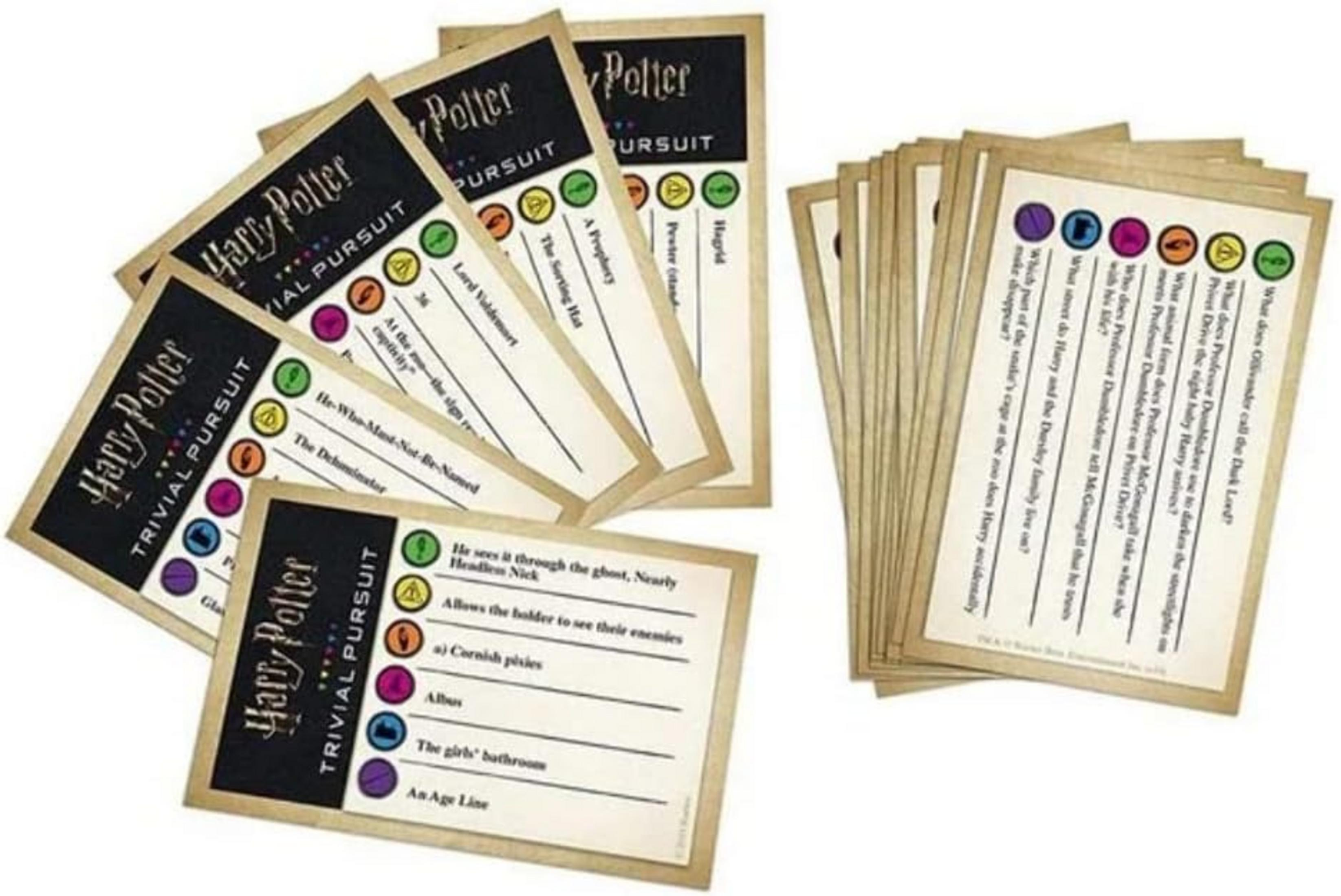 Pilas de cartas de Harry Potter Trivial Pursuit, algunas muestran preguntas y círculos de colores.