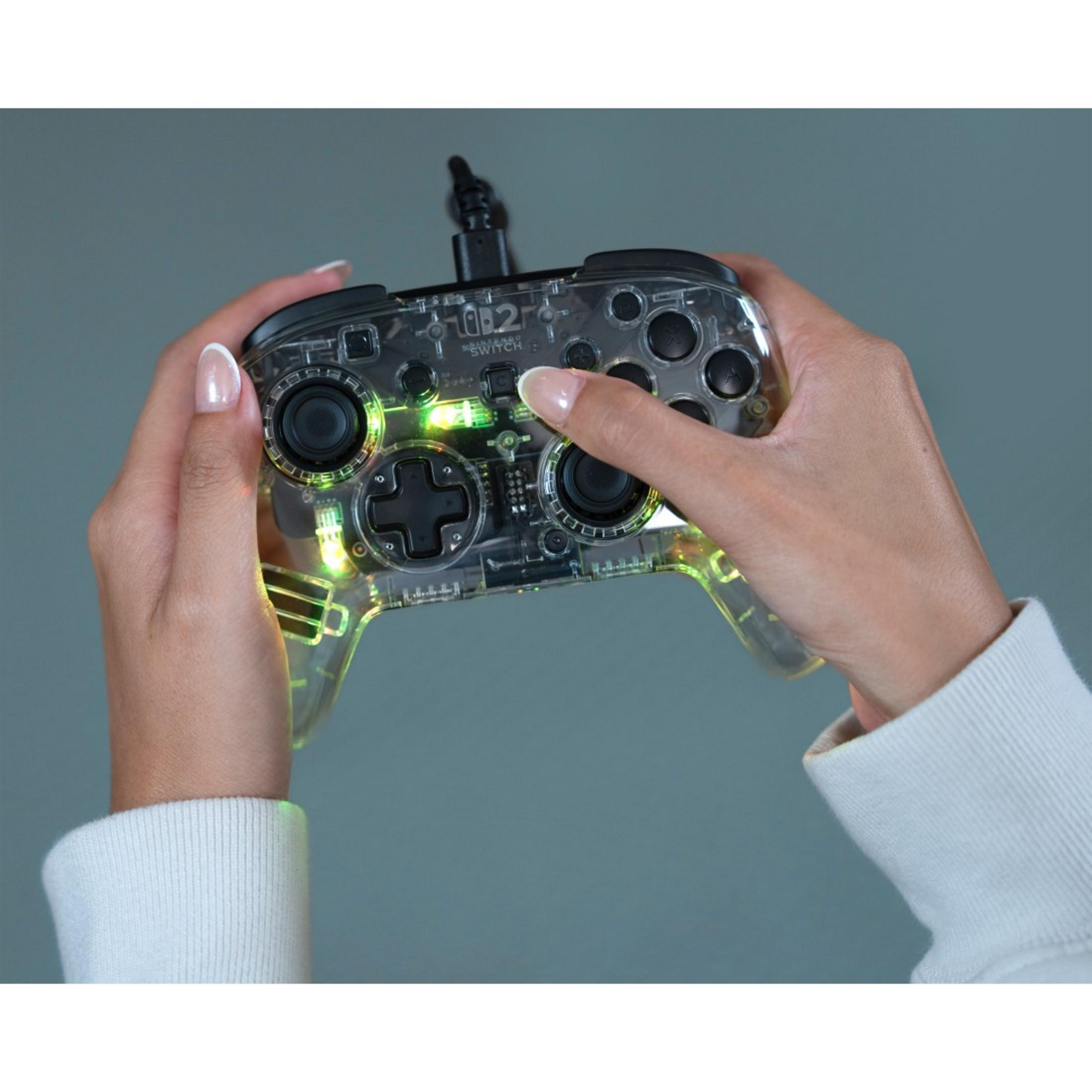 Controller trasparente con luci verdi, tenuto da mani con la manicure.