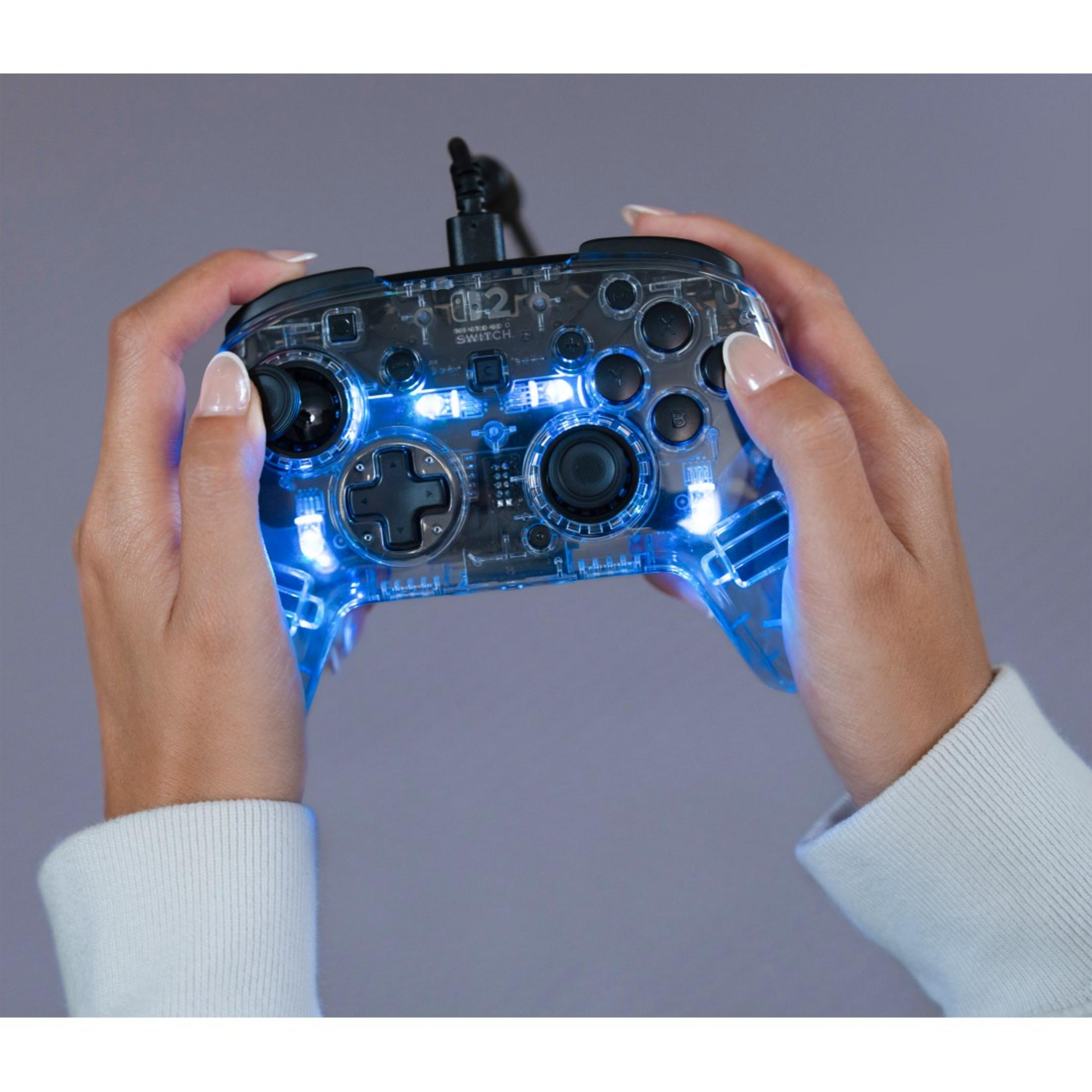 Mani che tengono un controller da gioco trasparente con luci blu.