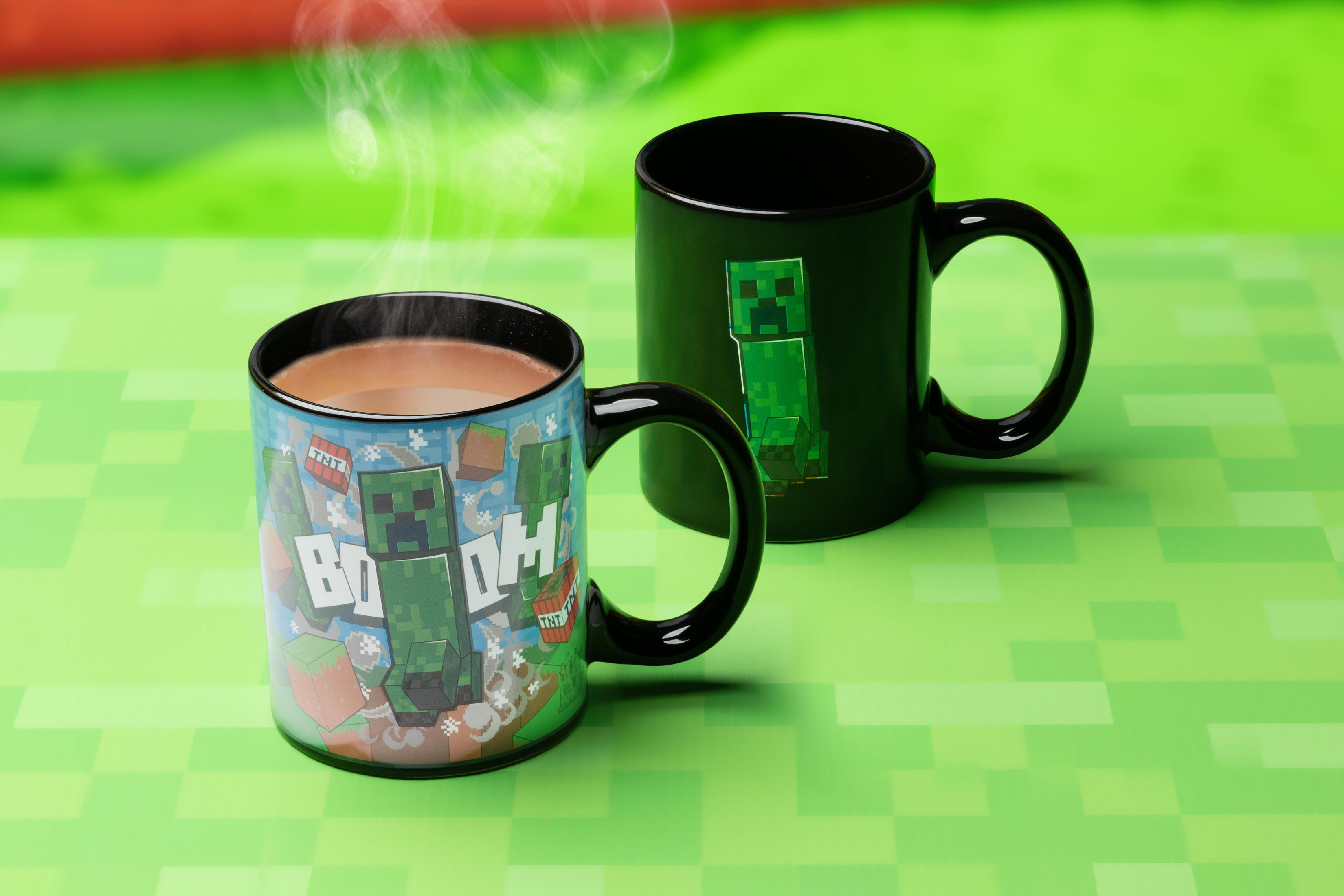Dos tazas de Minecraft con diseños de Creeper sobre fondo verde.