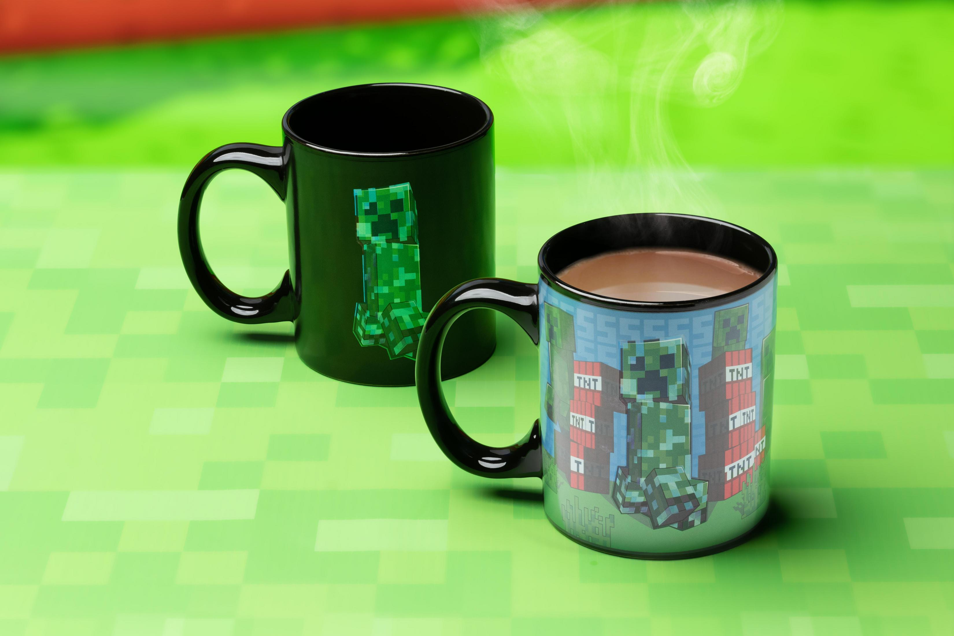 Dos tazas de Minecraft sobre fondo verde, una con Creeper, otra con TNT.