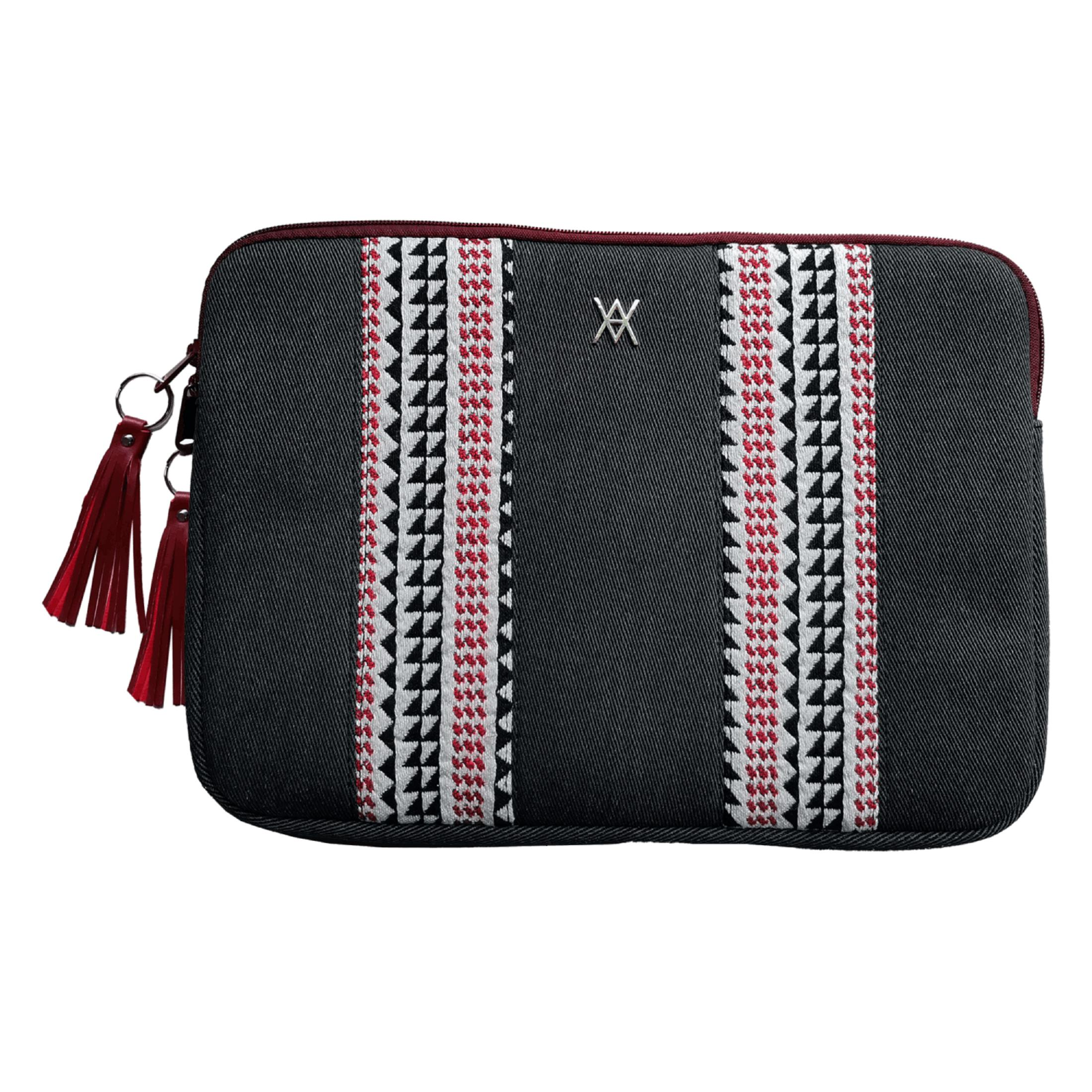 Bolso negro con bordados rojos y blancos y borlas.