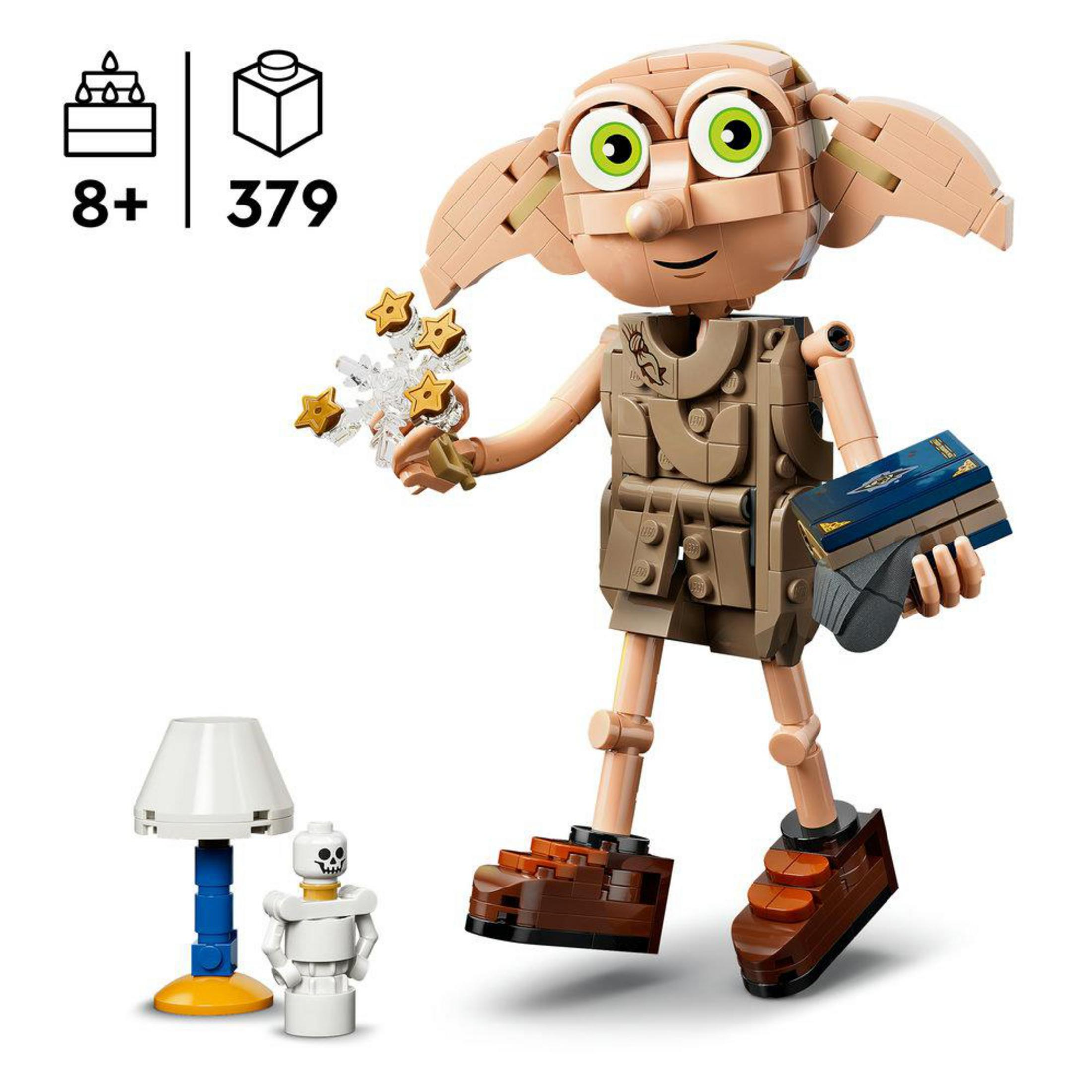 Figurka Lego Dobby trzymająca gwiazdy i książkę. Obok mała lampa i szkielet.