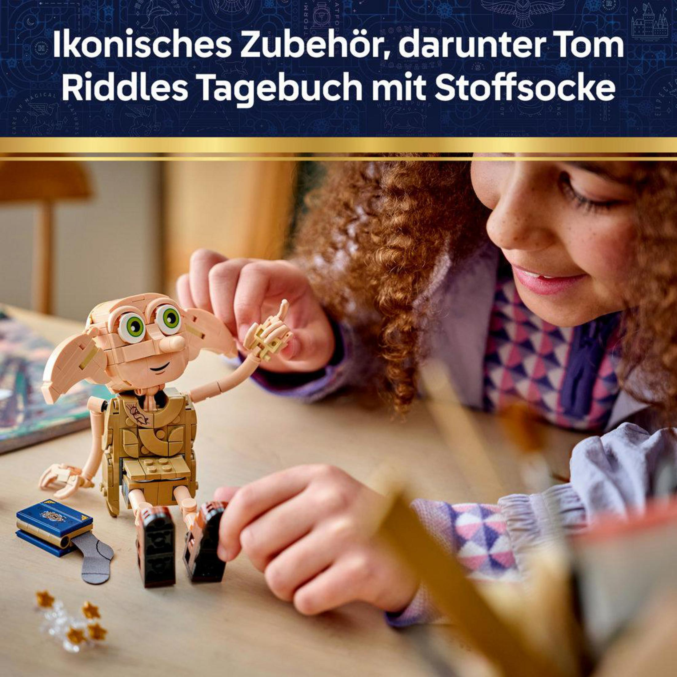 Dziecko bawi się figurką Dobby'ego, obok dziennik i skarpetka.