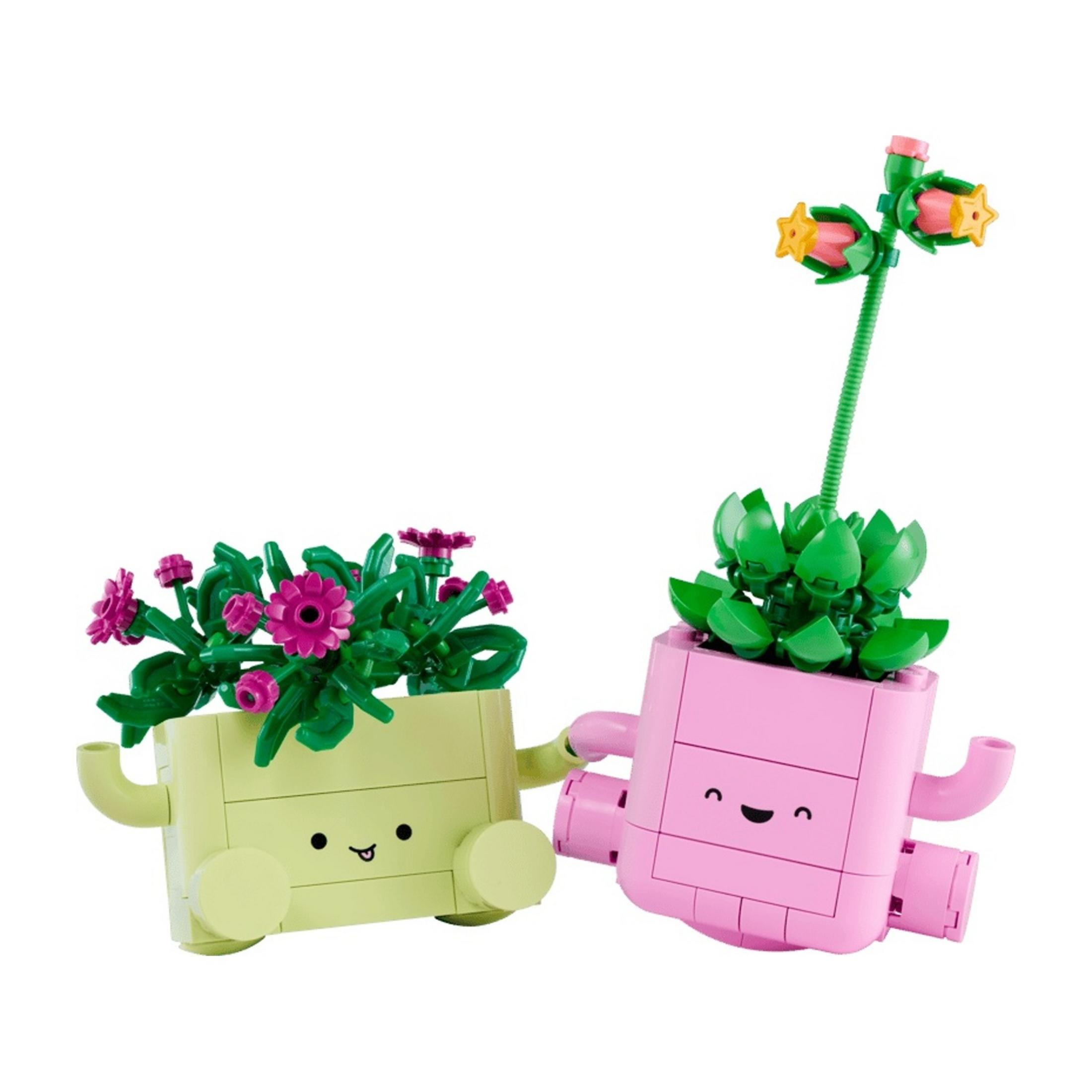 İki Lego saksı, biri pembe çiçekli açık yeşil, biri yeşil yapraklı ve çiçekli pembe.