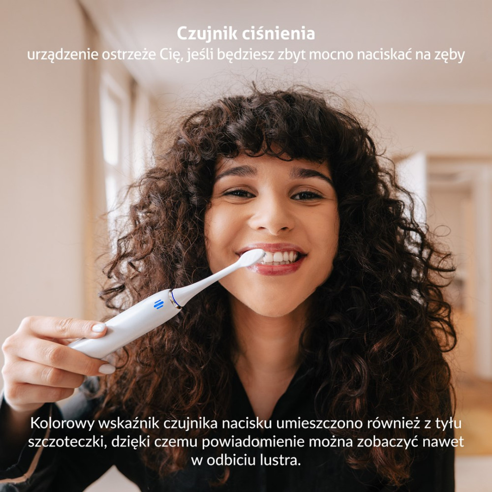 Donna si lava i denti con spazzolino elettrico; sensore di pressione si accende.