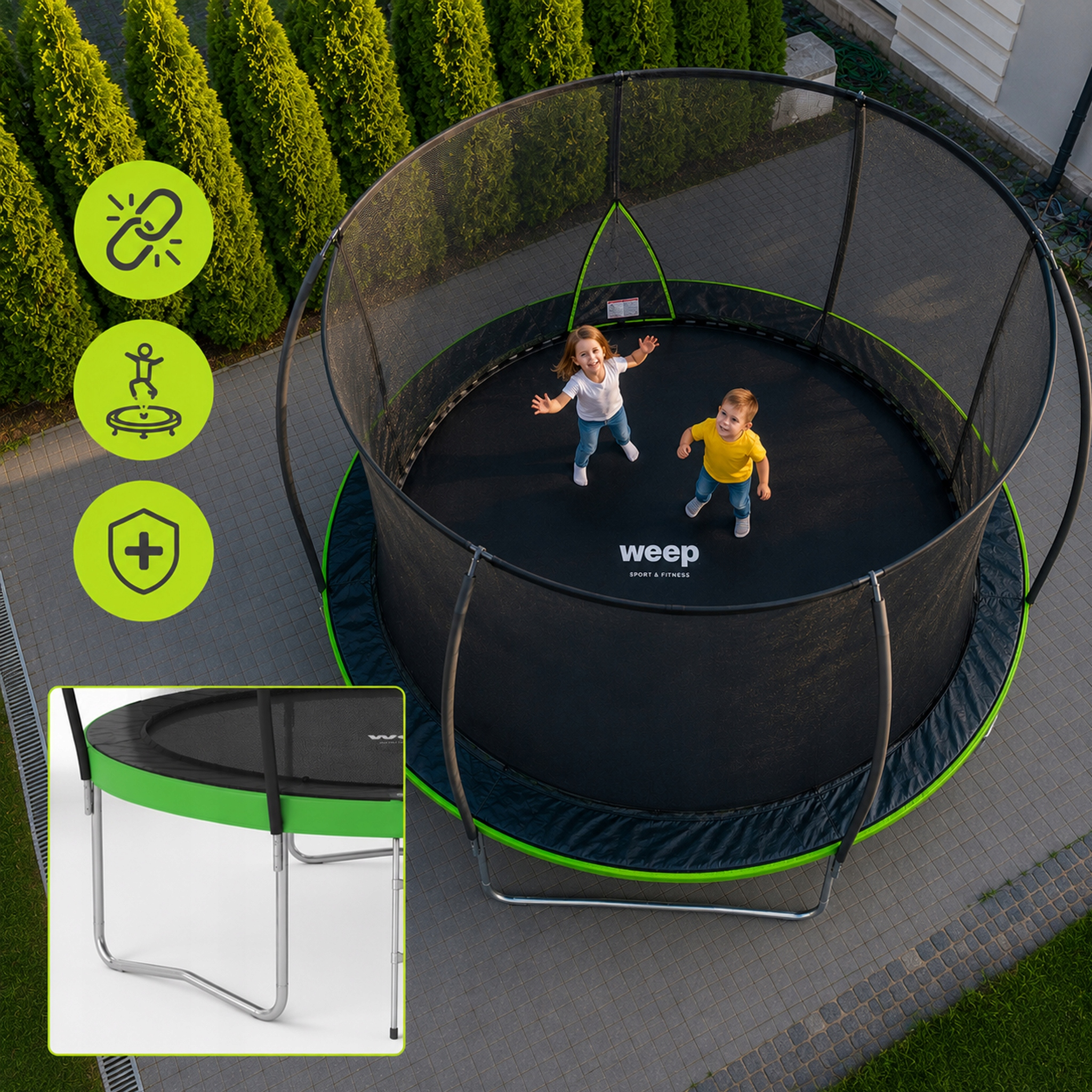 Dwoje dzieci na trampolinie zewnętrznej z zielonym obrzeżem i siatką zabezpieczającą.