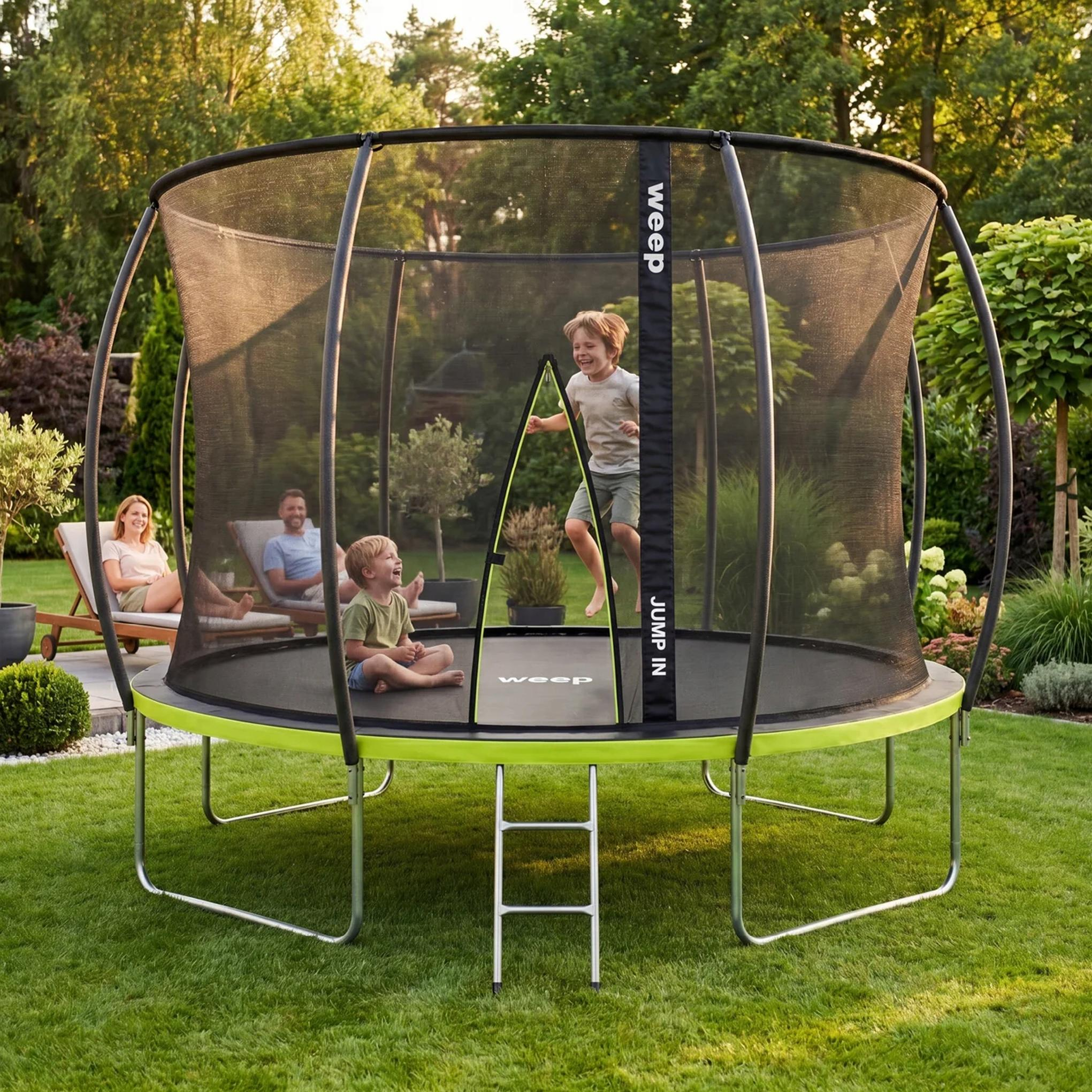 Dzieci na trampolinie w ogrodzie, rodzice relaksują się na leżakach.