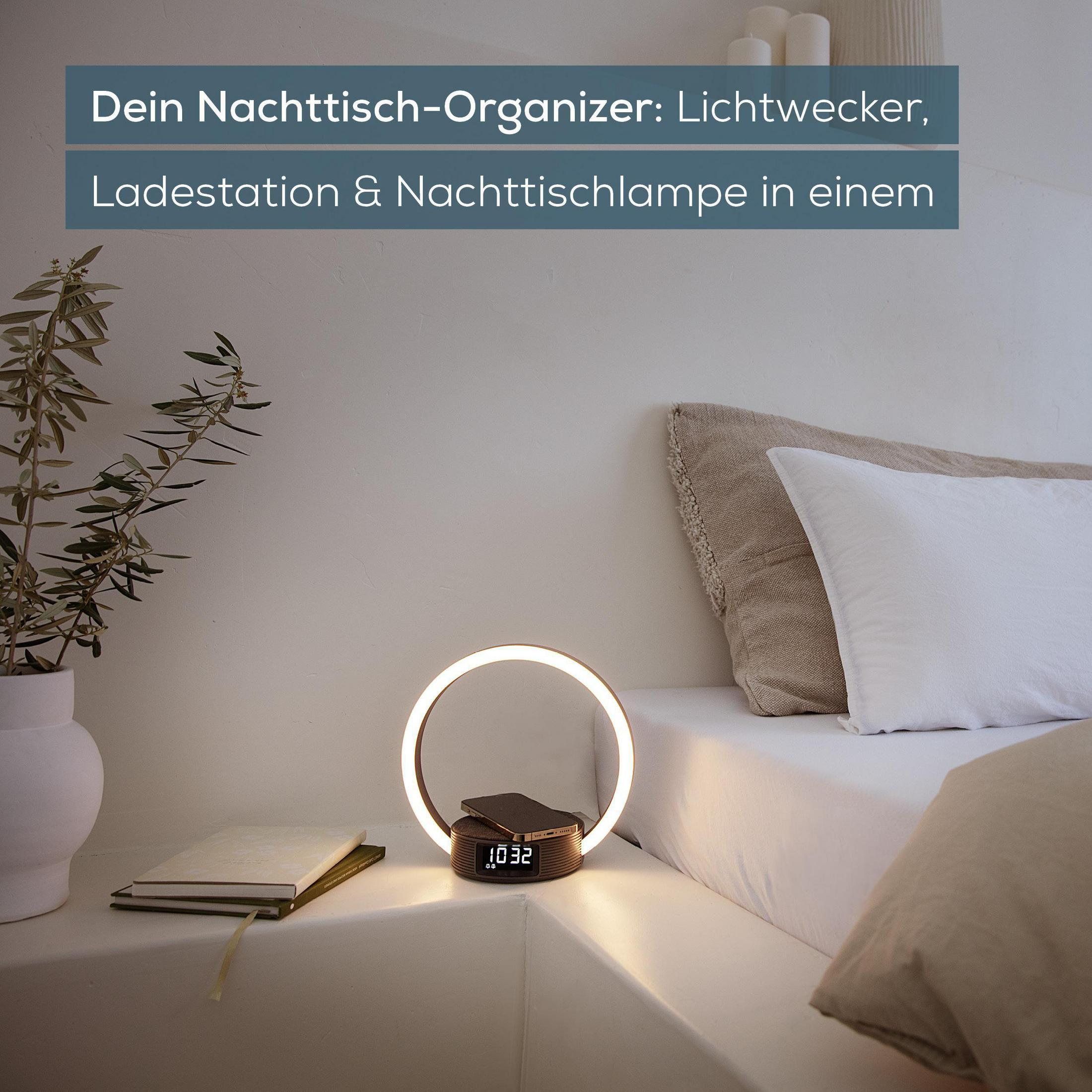 Organizzatore da comodino con lampada, stazione di ricarica e orologio su un letto.