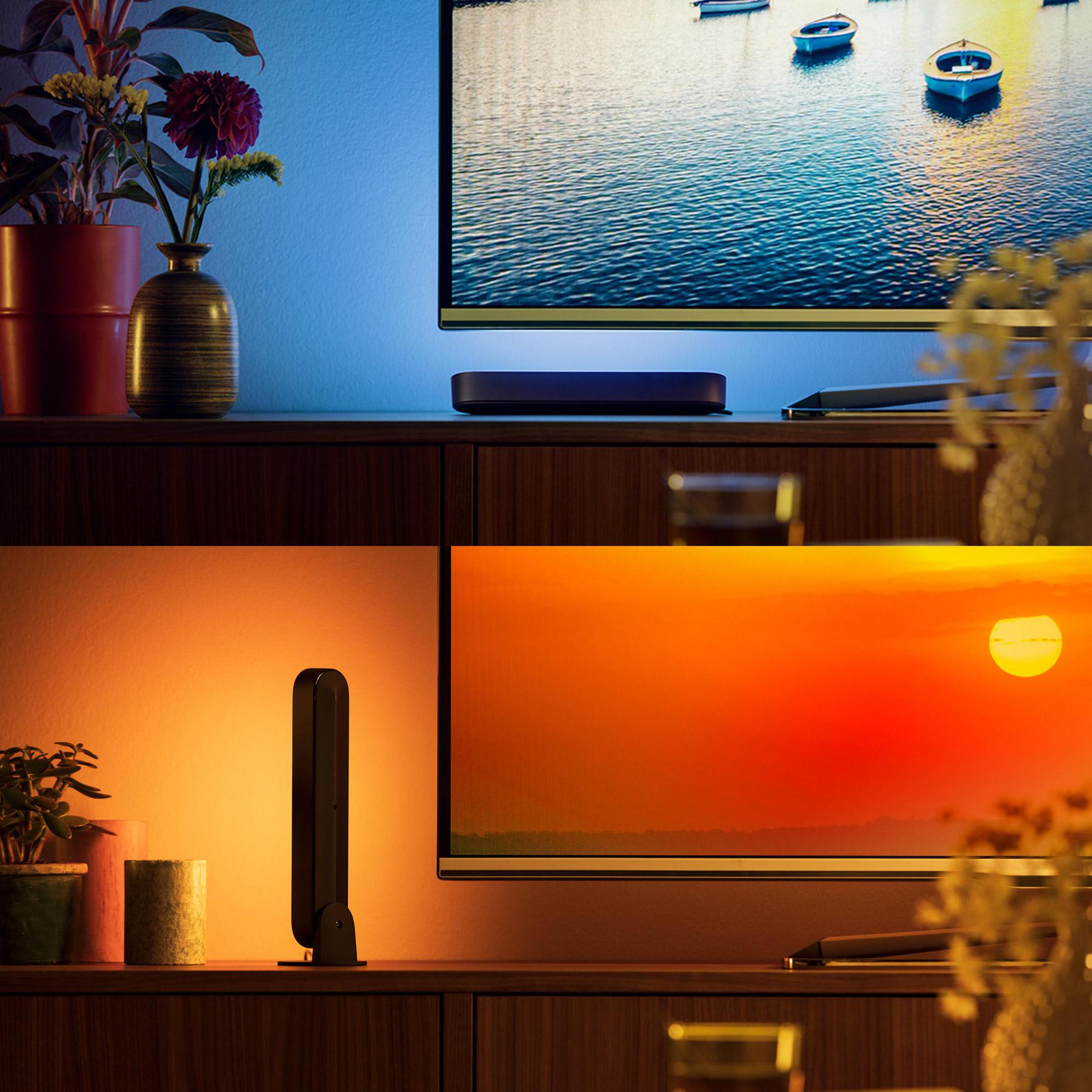 Un TV mostra barche sull'acqua. Accanto c'è una lampada.