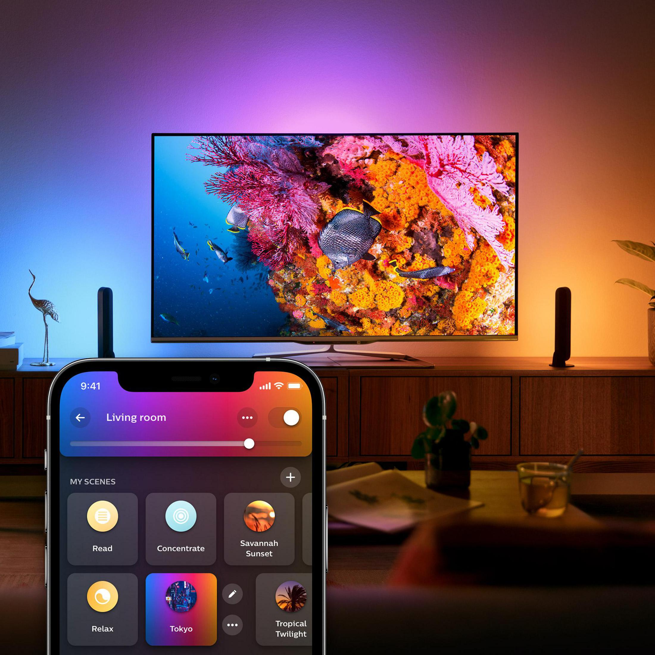 Uno smartphone mostra scene di illuminazione, mentre una TV visualizza una scena subacquea.