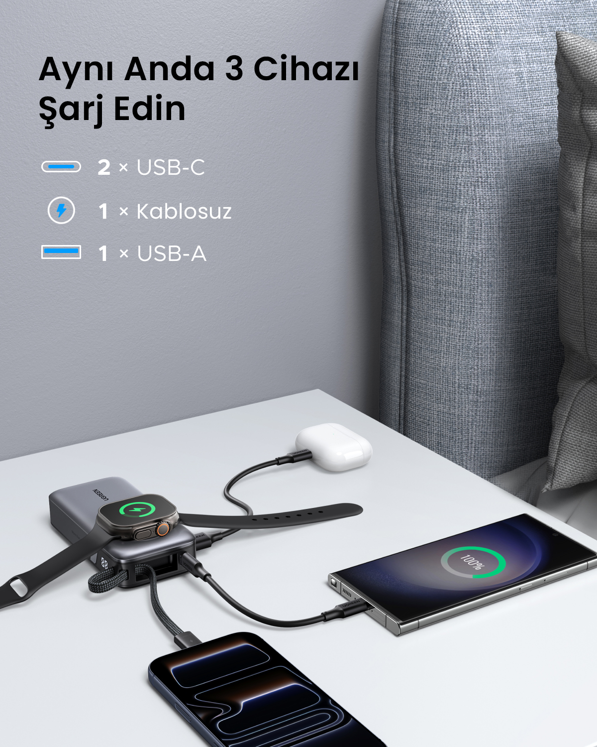 Gri şarj cihazı, Apple Watch, AirPods ve iki telefonu USB-C ve USB-A ile şarj eder.
