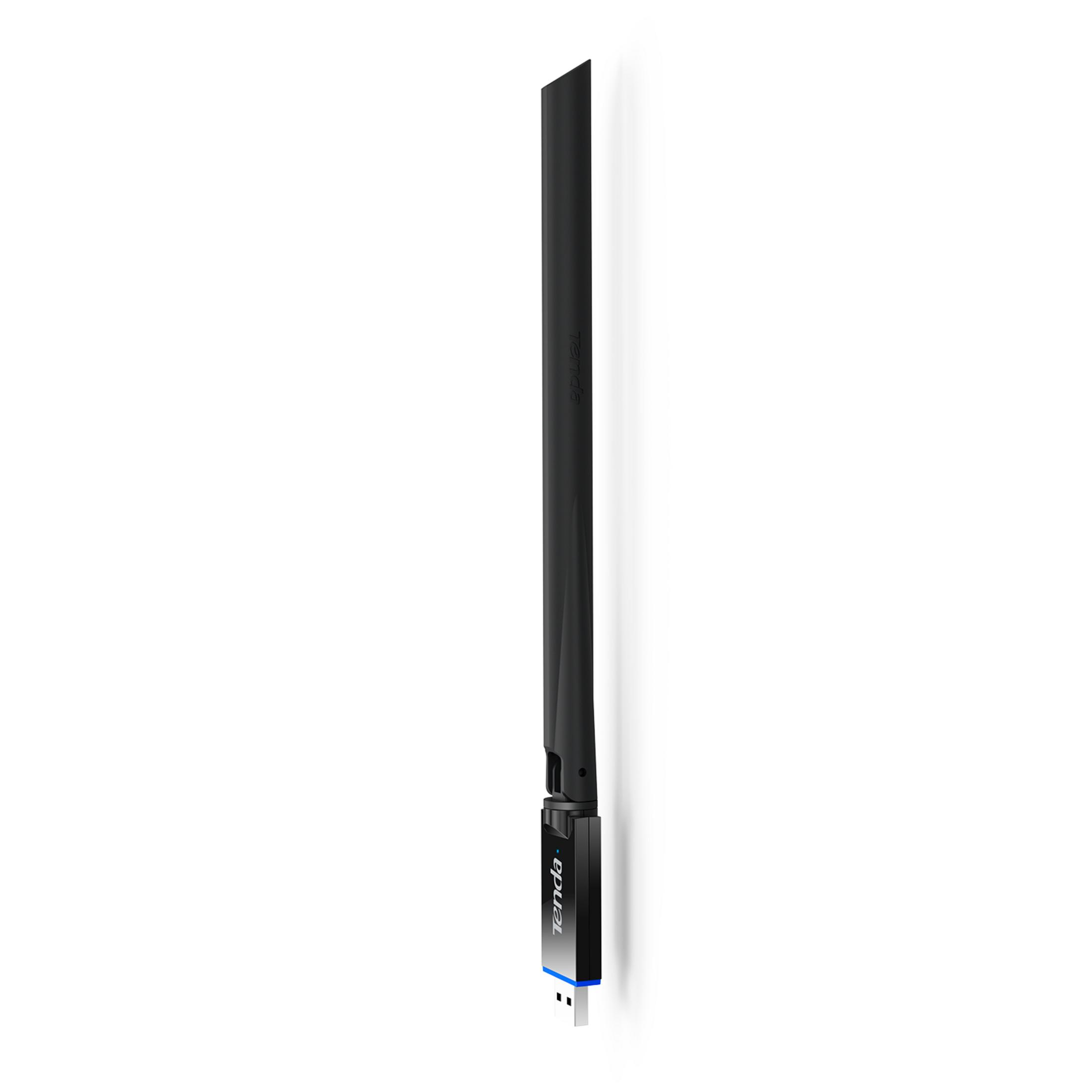 Un adaptador WiFi Tenda negro con antena y conector USB se alza verticalmente.