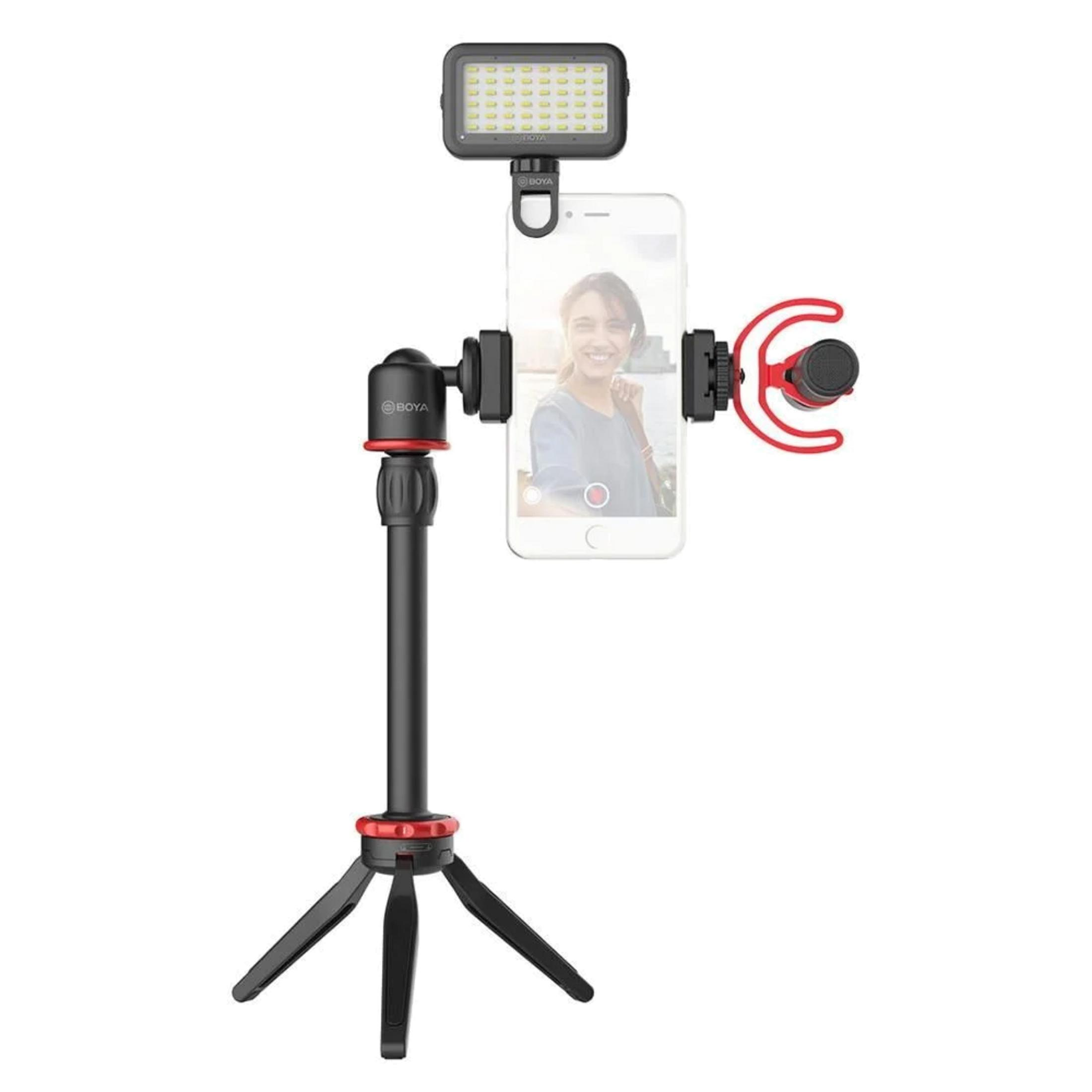 Un smartphone está montado en un trípode con luz y micrófono adjuntos.