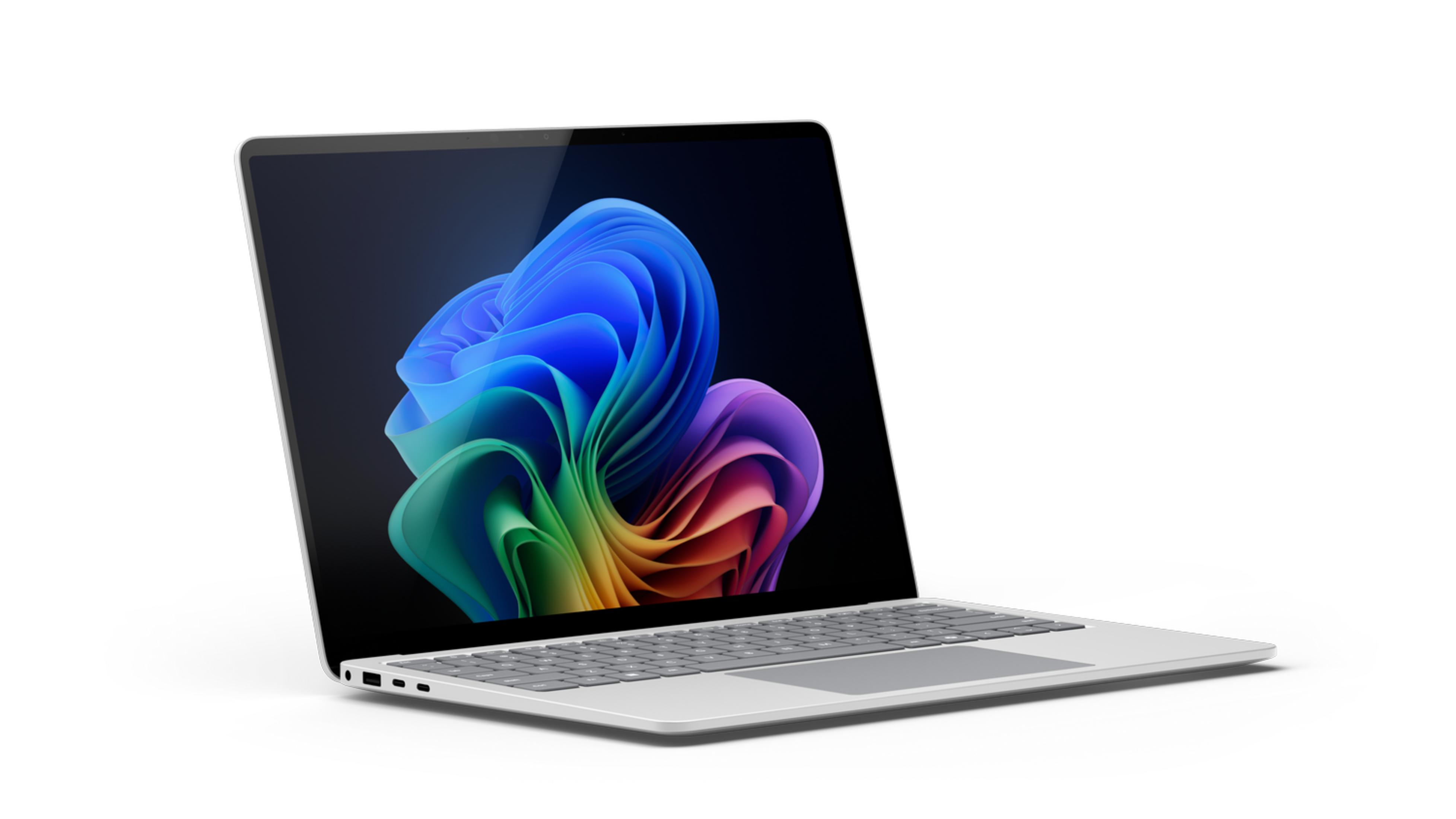 Srebrny laptop wyświetlający kolorowe abstrakcyjne tło na ekranie.