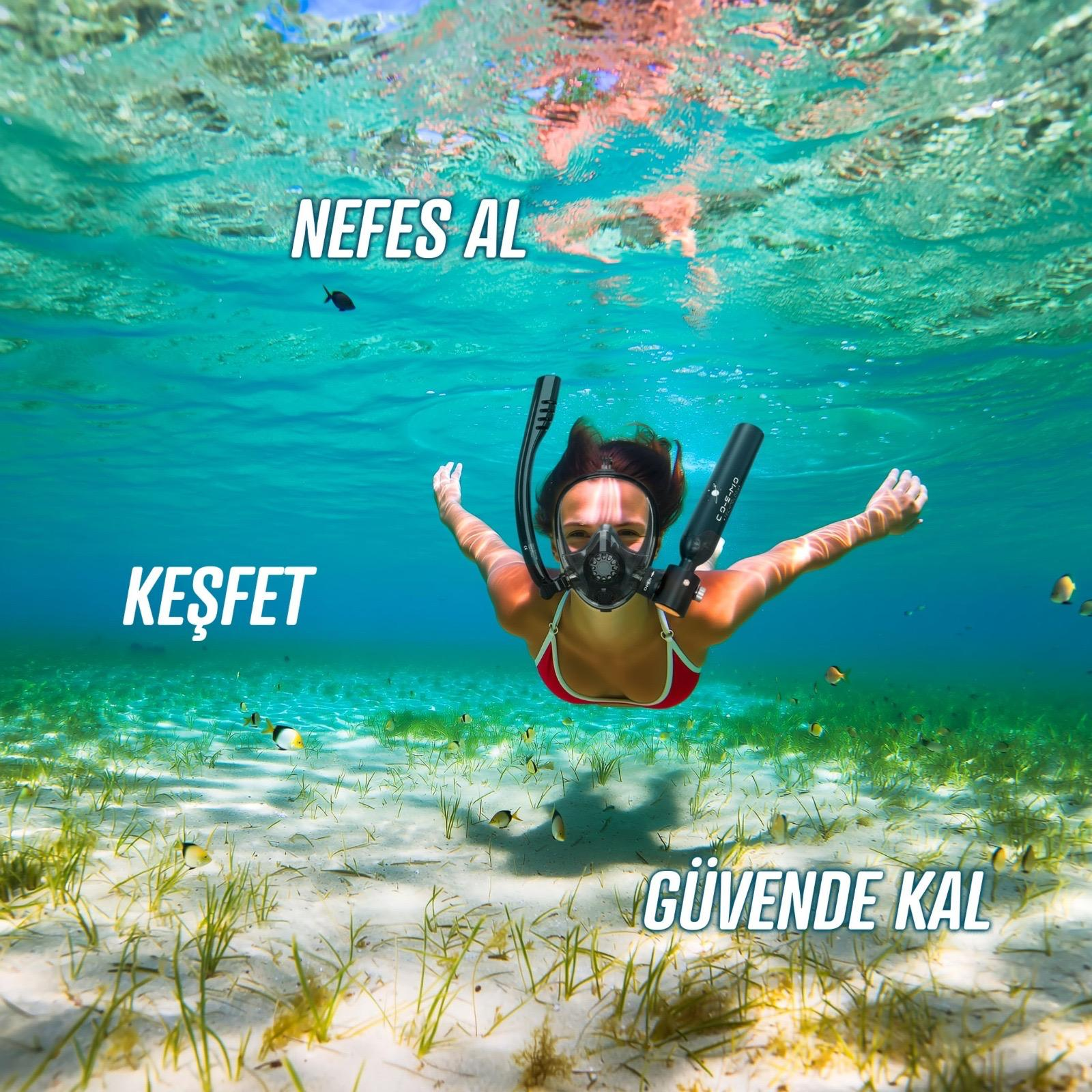 Kadın balıkların olduğu kumlu deniz tabanında berrak suda şnorkelle yüzüyor.