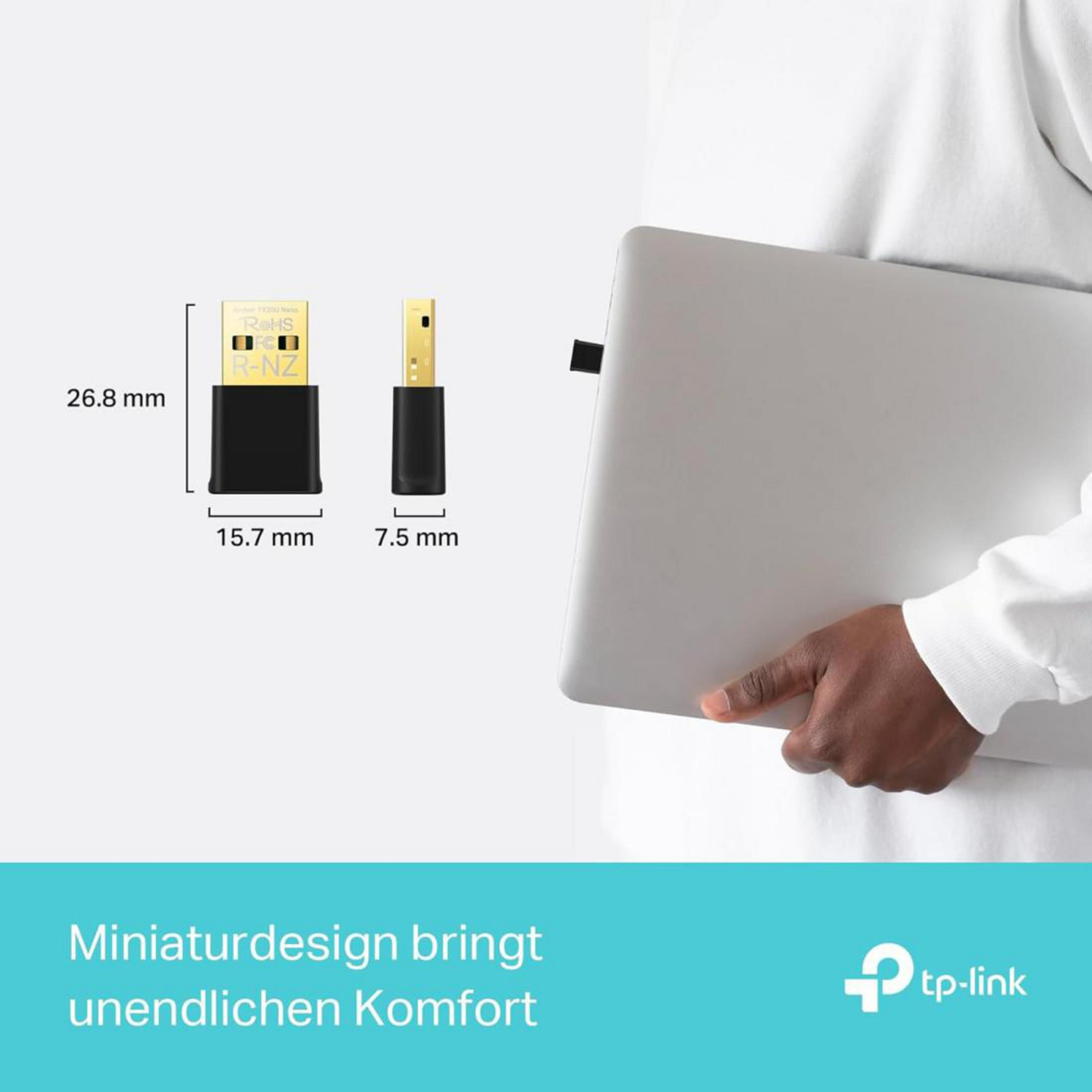Un adaptador USB negro con dimensiones junto a un portátil sostenido por una mano.