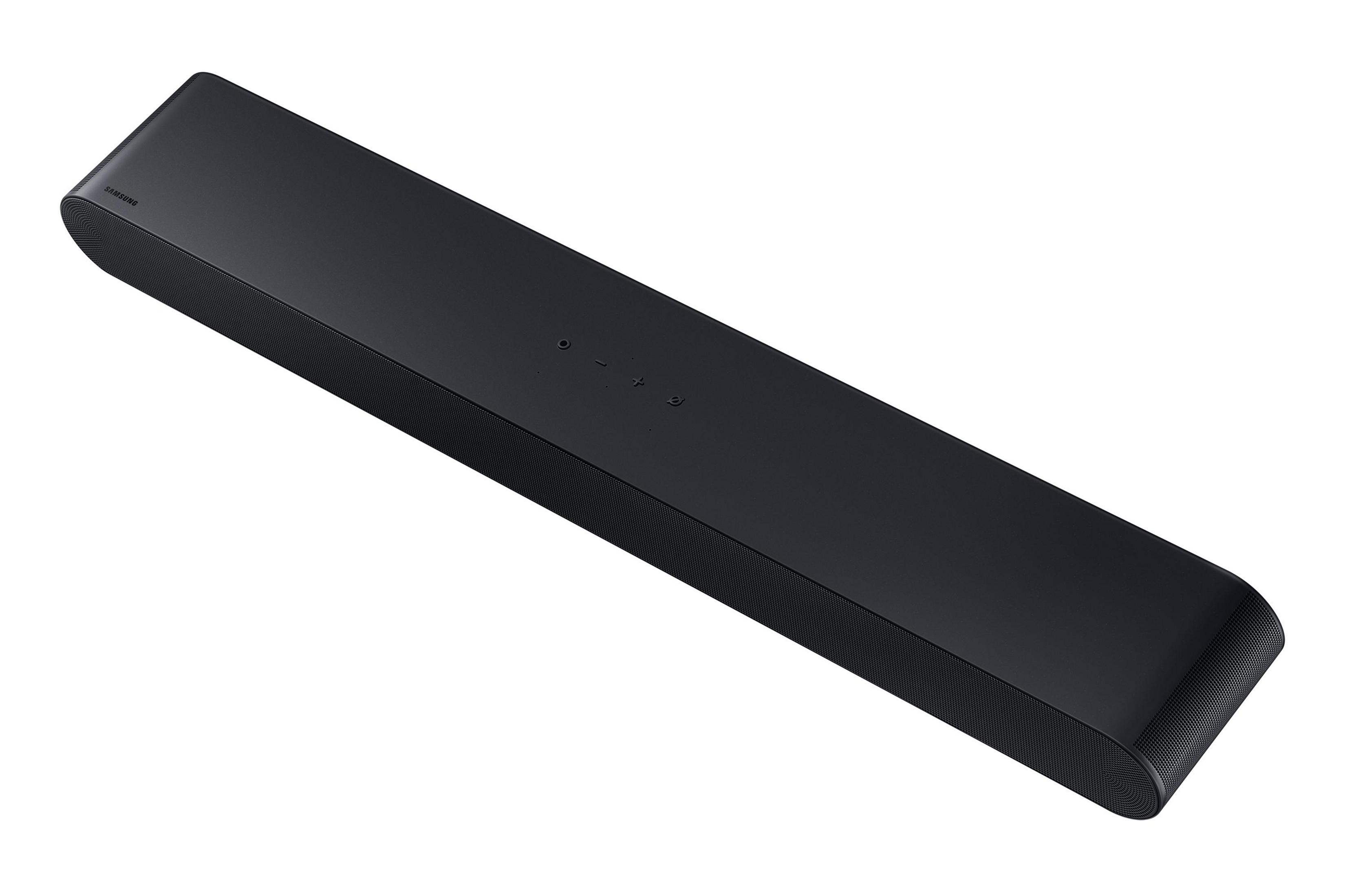 Barre de son Samsung noire avec boutons de commande sur le dessus, sur fond blanc.