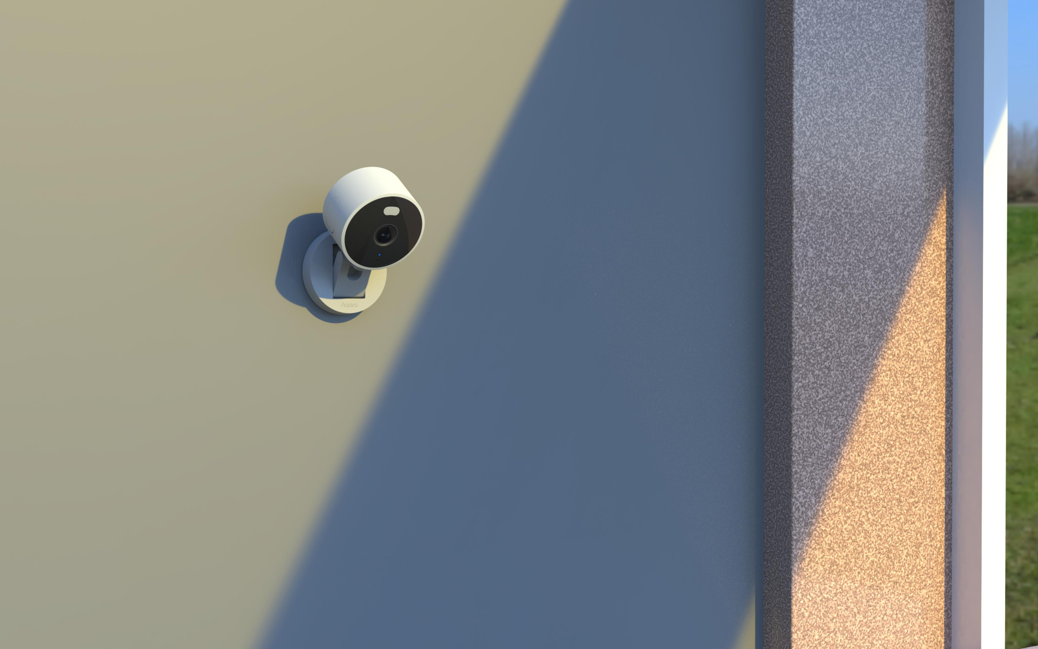 A white security camera is mounted on a wall. Sunlight casts shadows.