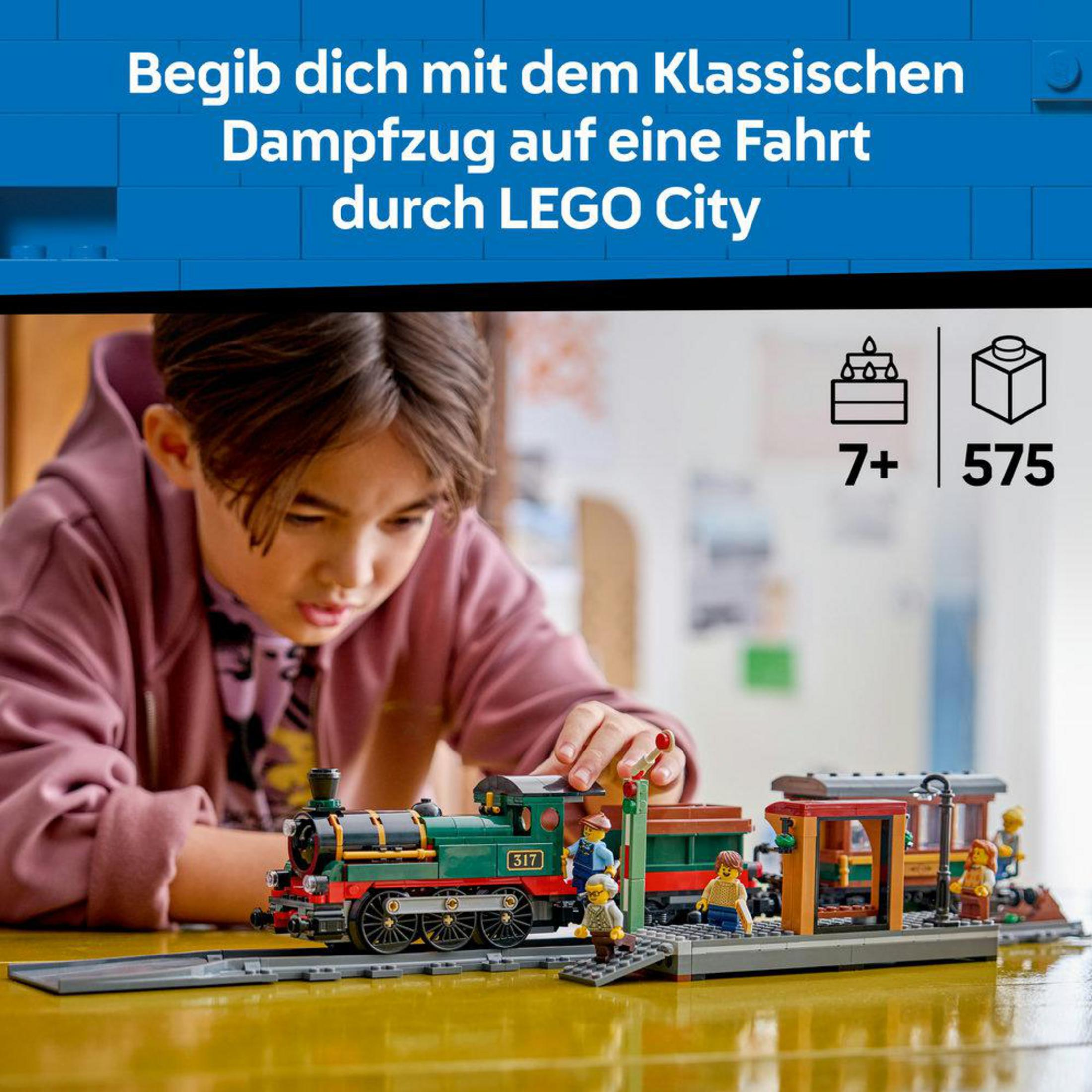 Çocuk, LEGO buharlı lokomotifi ve vagonlarıyla raylarda oynuyor.