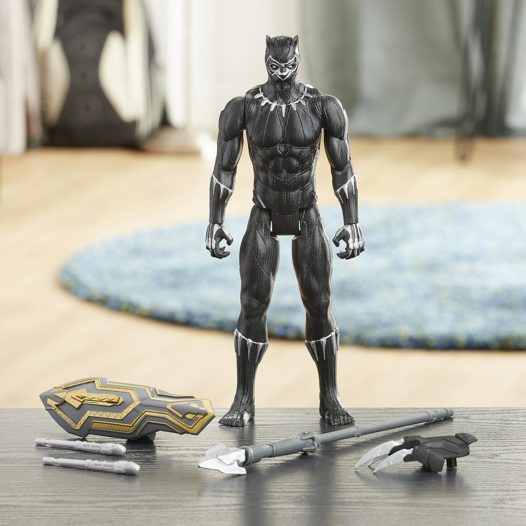 Action figure di Black Panther con accessori: scudo, lancia e artigli su tavolo.