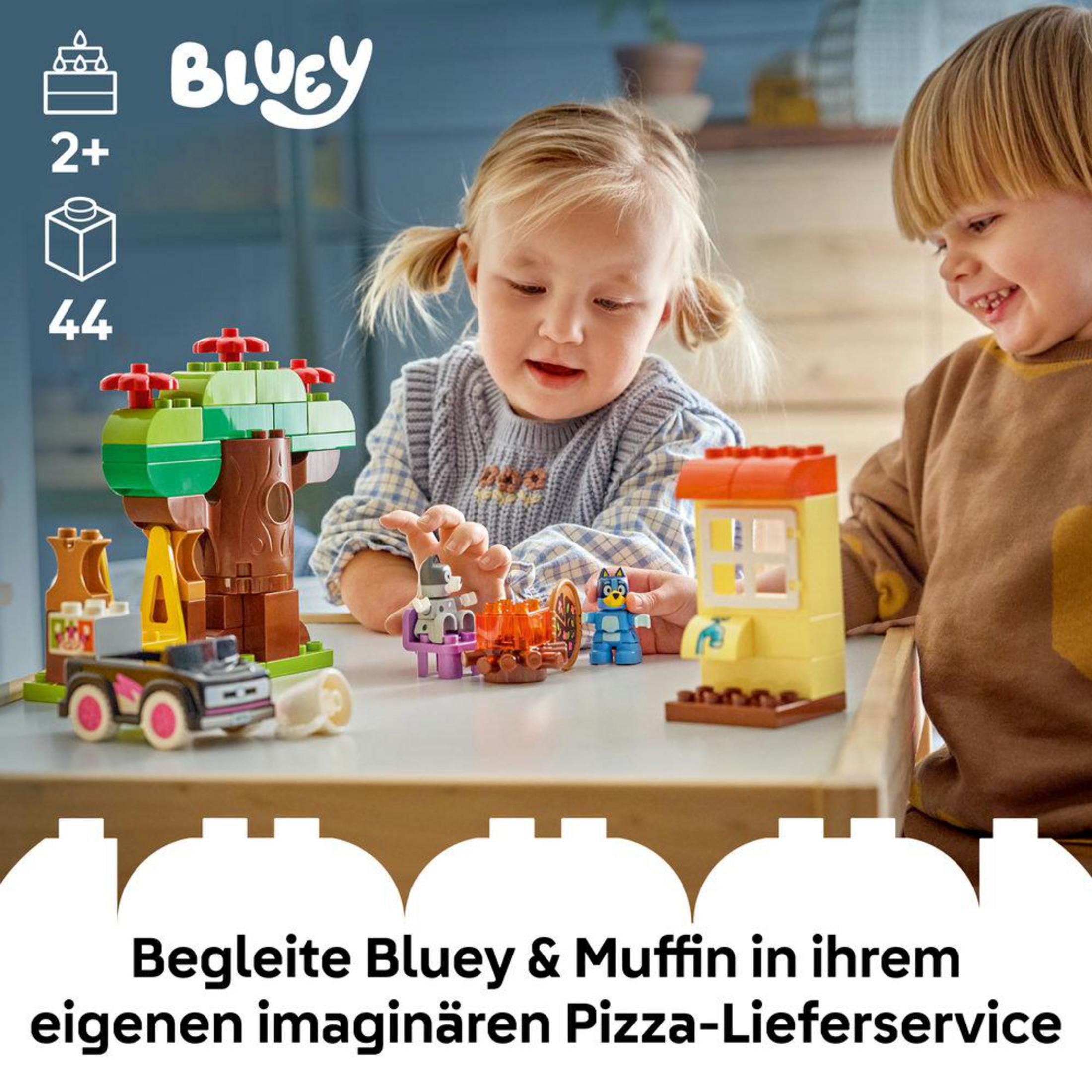 Niños juegan con set Lego de Bluey: casa árbol, coche, figuras, horno pizza.