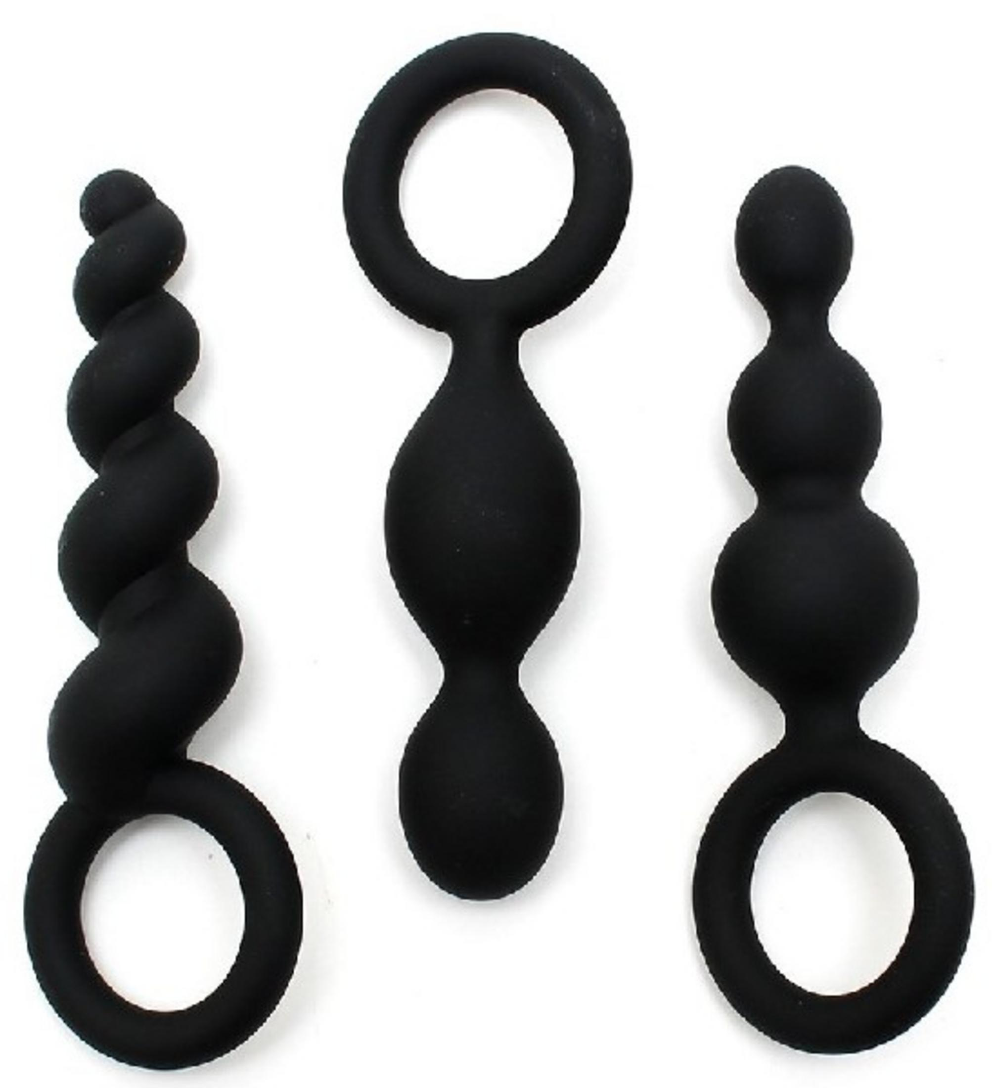 Drei schwarze, längliche Objekte mit Ringen, eines spiralförmig, auf weißem Grund.