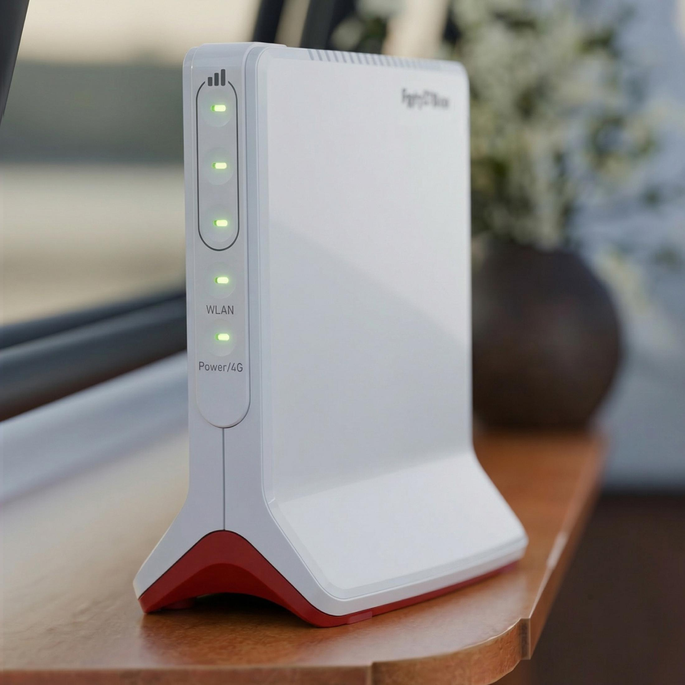 Ein weißer Router mit roten Akzenten und grünen LEDs auf einem Holztisch.