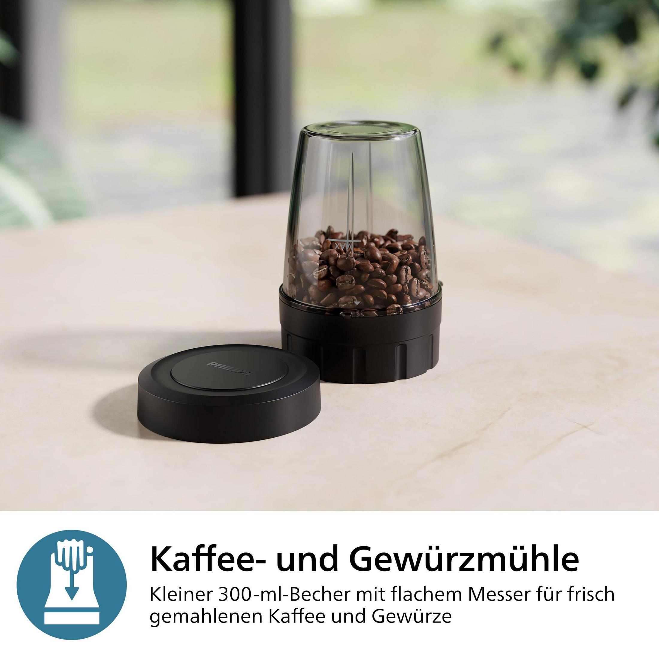 Un contenitore di vetro con chicchi di caffè e un coperchio nero su un tavolo.