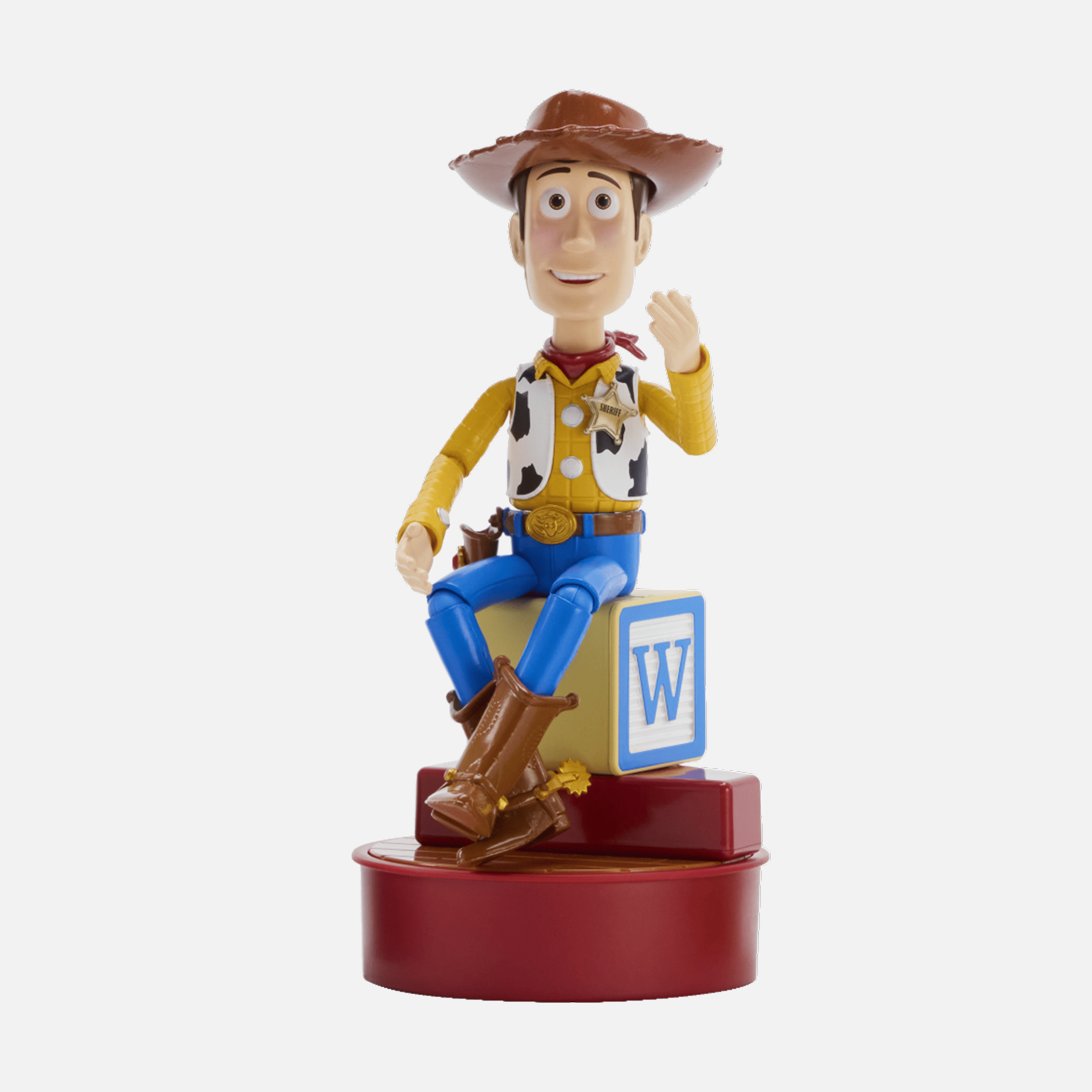 Figura de Woody se sienta en un bloque de juguete con la letra W.