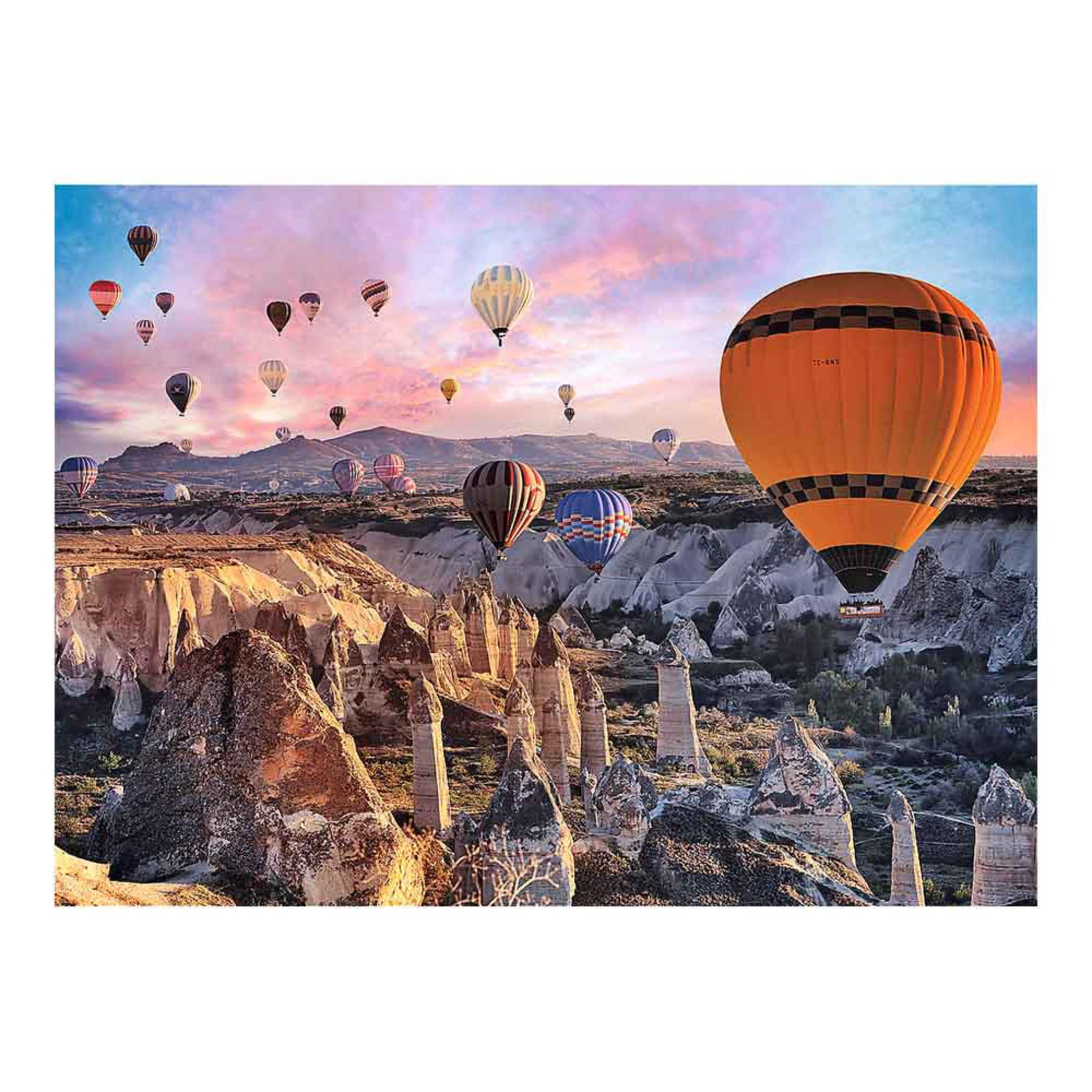 Globos aerostáticos ascienden sobre formaciones rocosas en Capadocia al amanecer.
