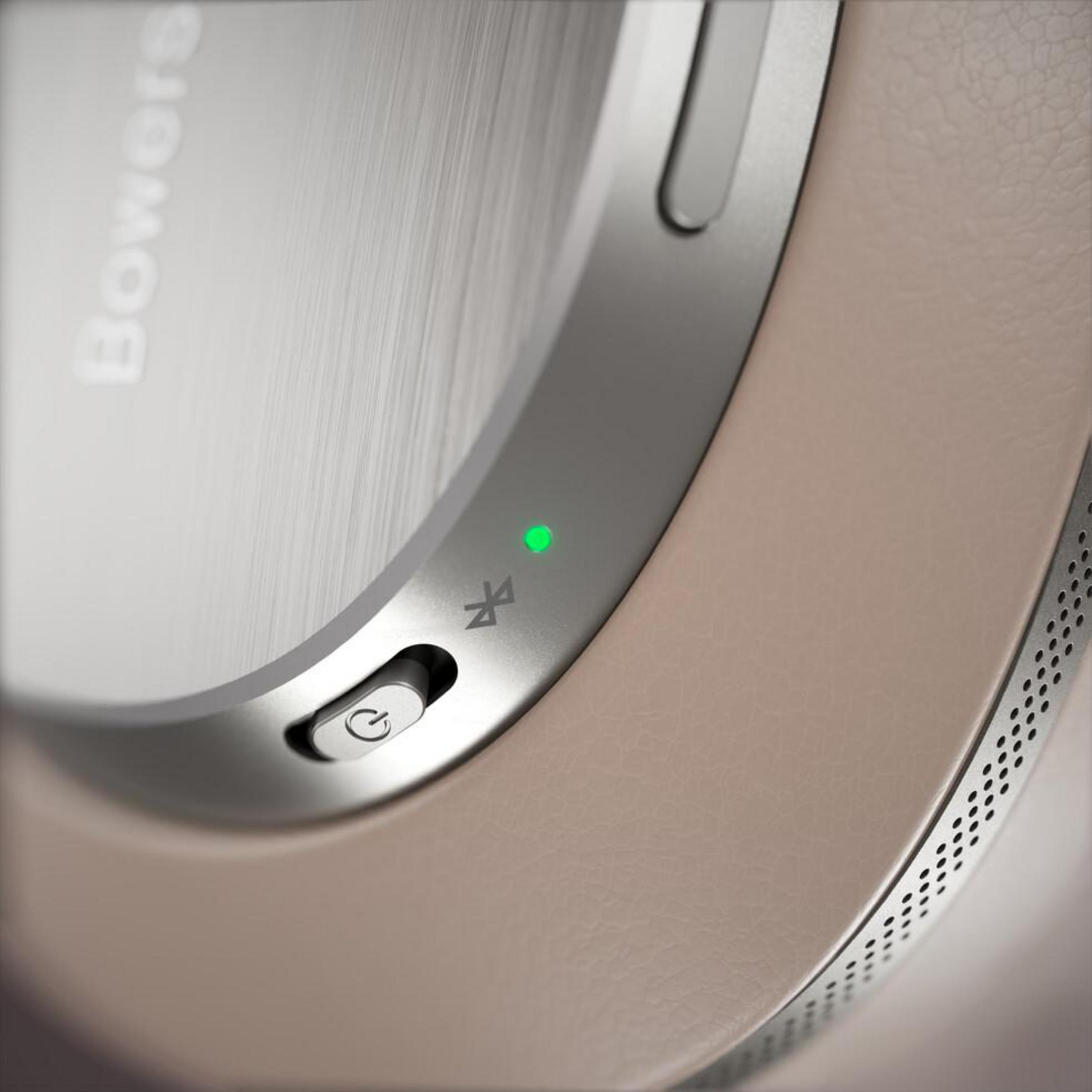 Primo piano di cuffie Bowers & Wilkins con pulsante di accensione, simbolo Bluetooth e spia verde.