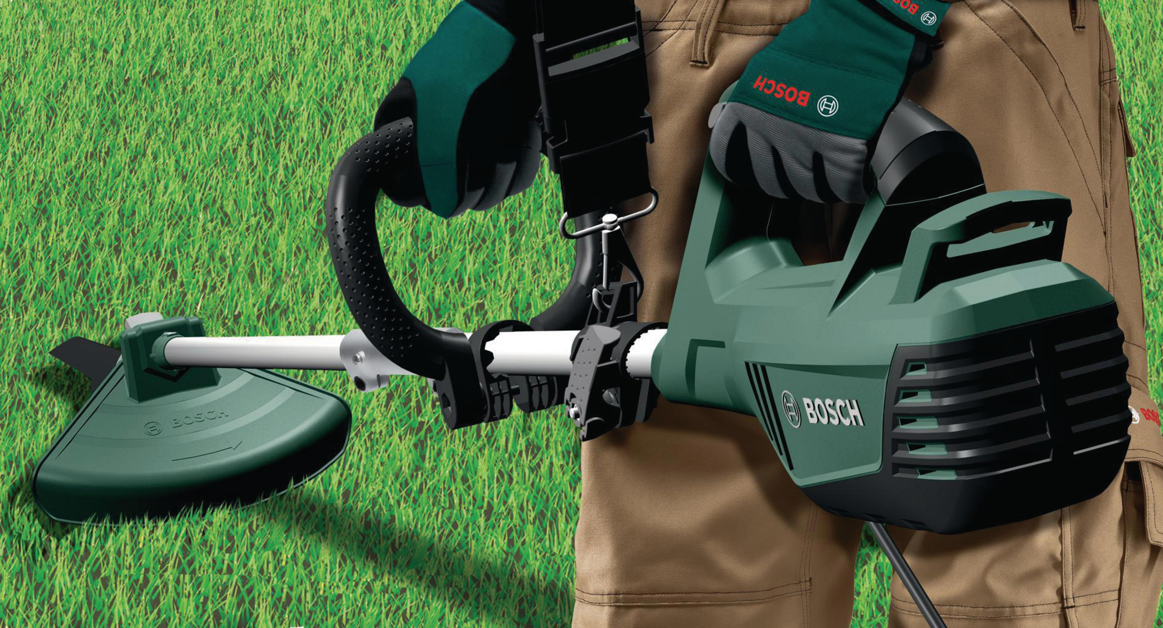 Grüner Bosch-Rasentrimmer mit schwarzem Griff und beigefarbener Hose.