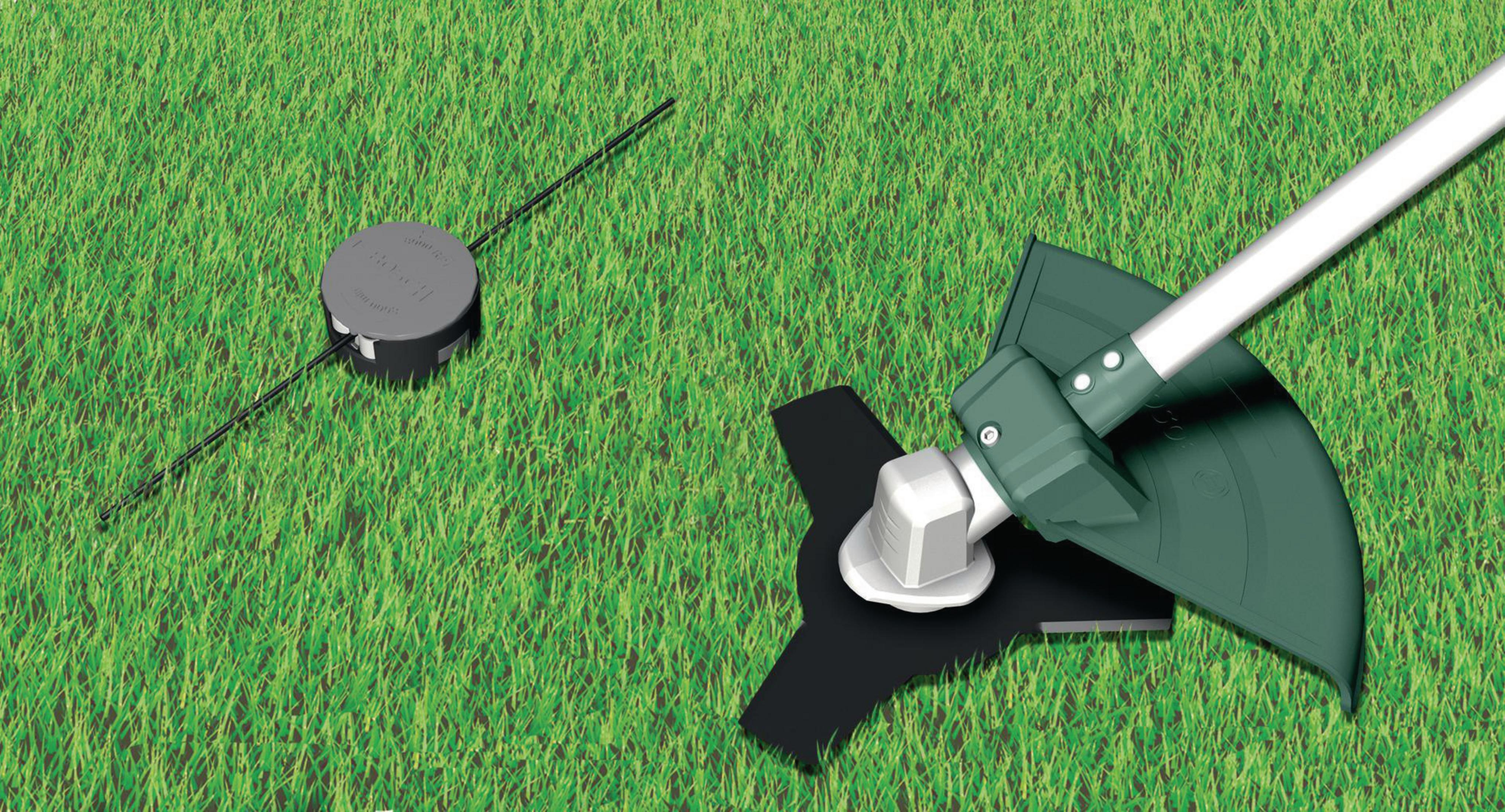 Ein Trimmerkopf mit schwarzer Klinge und ein Fadenkopf liegen auf grünem Gras.