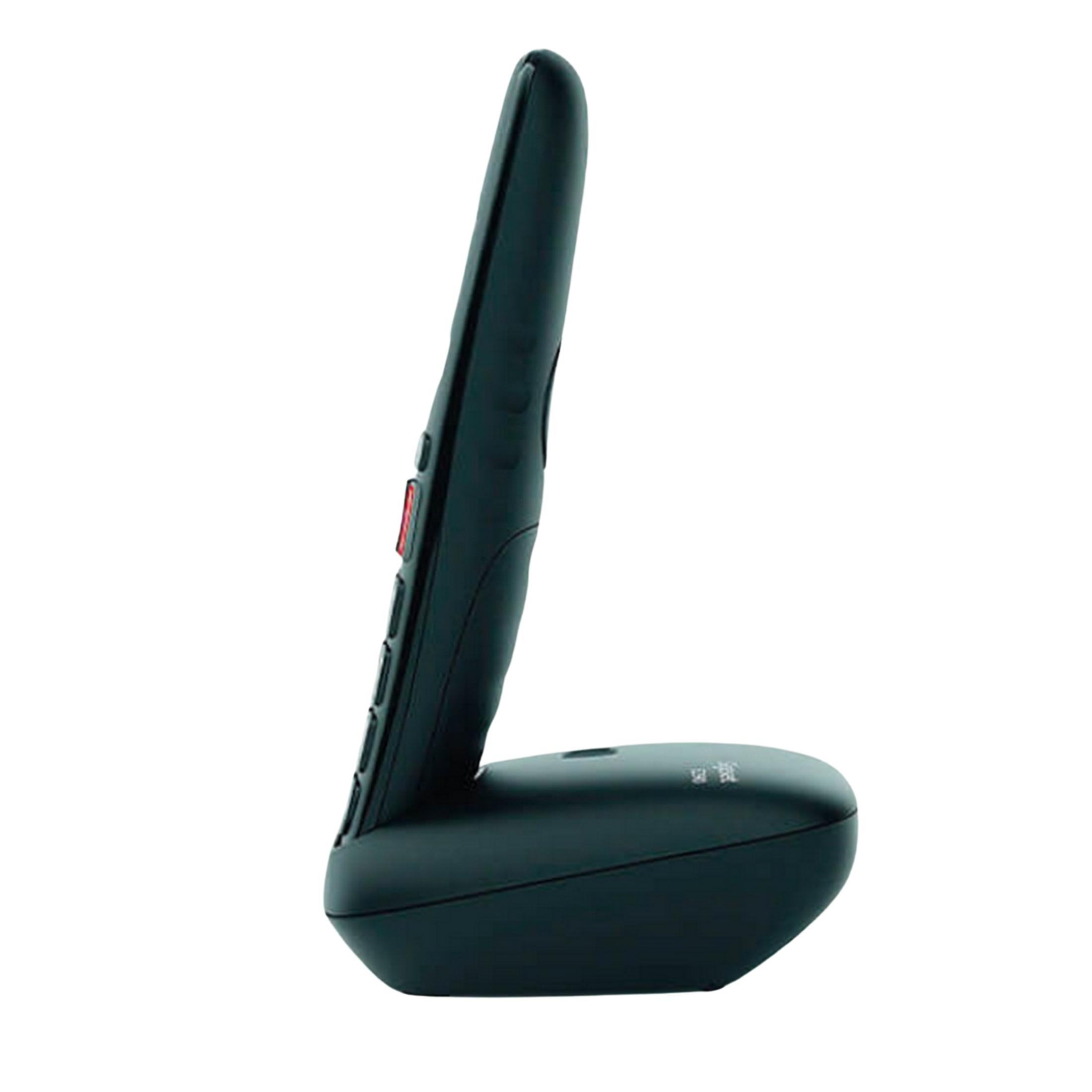 Un telefono cordless nero poggia sulla sua base, visto di lato.
