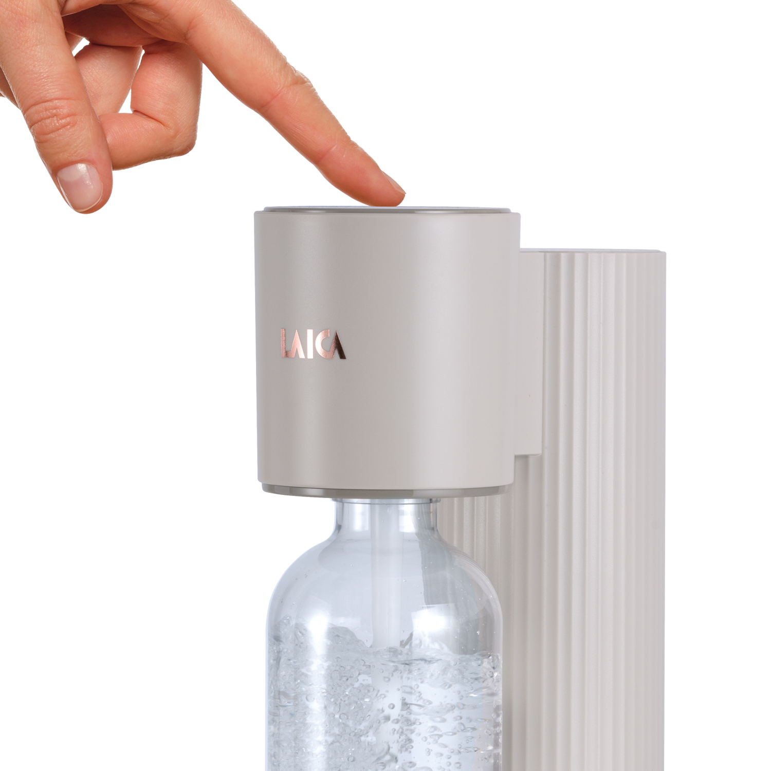 Una mano presiona el botón de un carbonatador de agua con una botella.