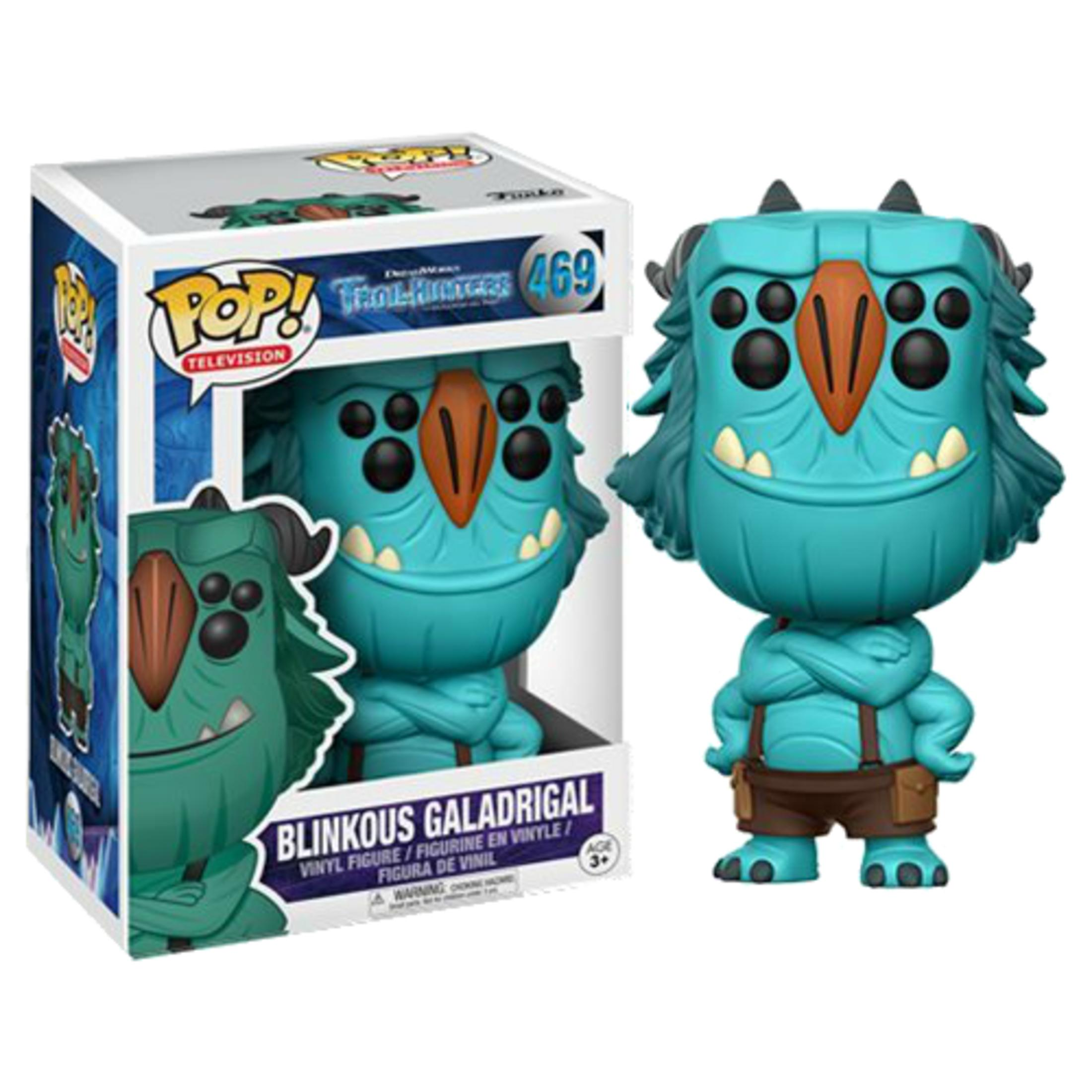 Eine blaue Trollfigur mit Hose und Hosenträgern neben einer Verpackung.